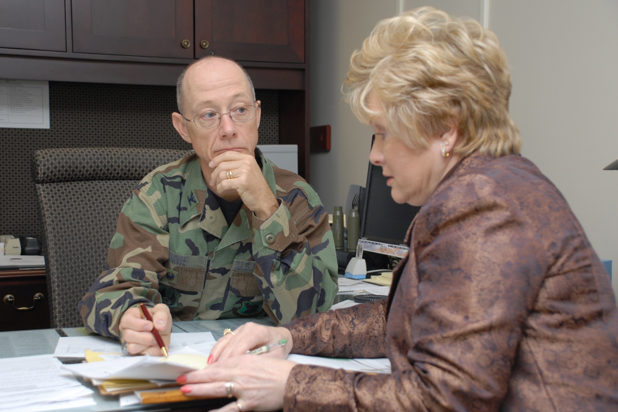 EGLIN AIR FORCE BASE, Fla. -- Col. Robert J. Rennie, 96th Medical Group administrator, speaks with Julie Moriyama during a meeeting at the hospital recently. Colonel Rennie was recently awarded the U.S. Air Force Maj. Gen. Michael K. Wyrick Commitment to Excellence Award for his influence and dedication to the medical professionals beginning May 1982. Over his career, Colonel Rennie has won several Air Force level awards. From deployments to Hurricane Andrew, he has provided medical care and direction acroos the board. IN his off-duty time, the colonel has held many positions with bicycling clubs, including Senior Olympics president. (U.S. Air Force photo by Staff Sgt. Mike Meares)