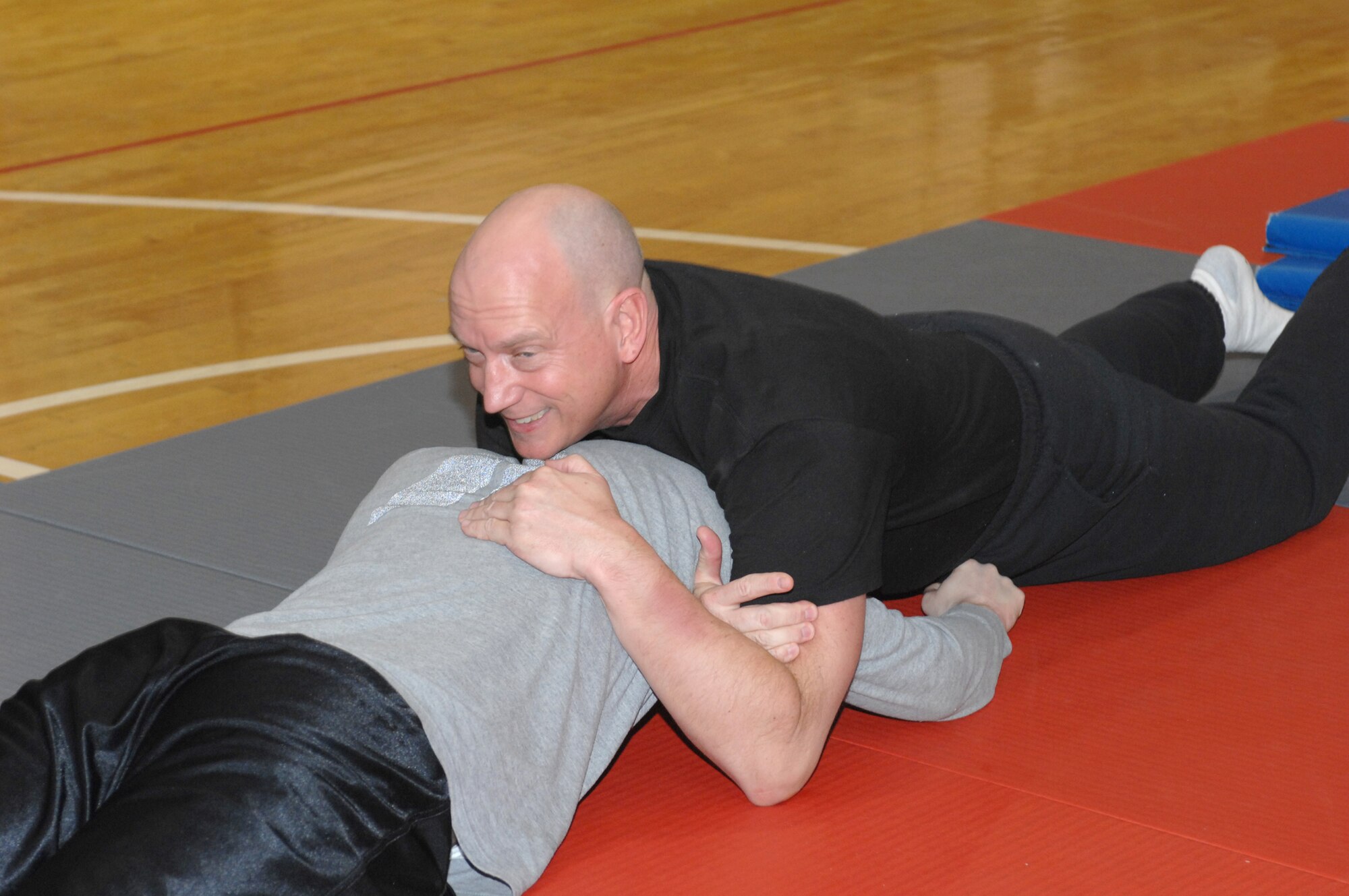 WHITEMAN AIR FORCE BASE, Mo. – Officer Doug Austin, Chenega Company, follows up his sprawl with a finishing technique designed to render his attacker unconscious or force him to submit to the officer Feb.19. (U.S. Air Force photo/Tech. Sgt. Samuel A. Park)