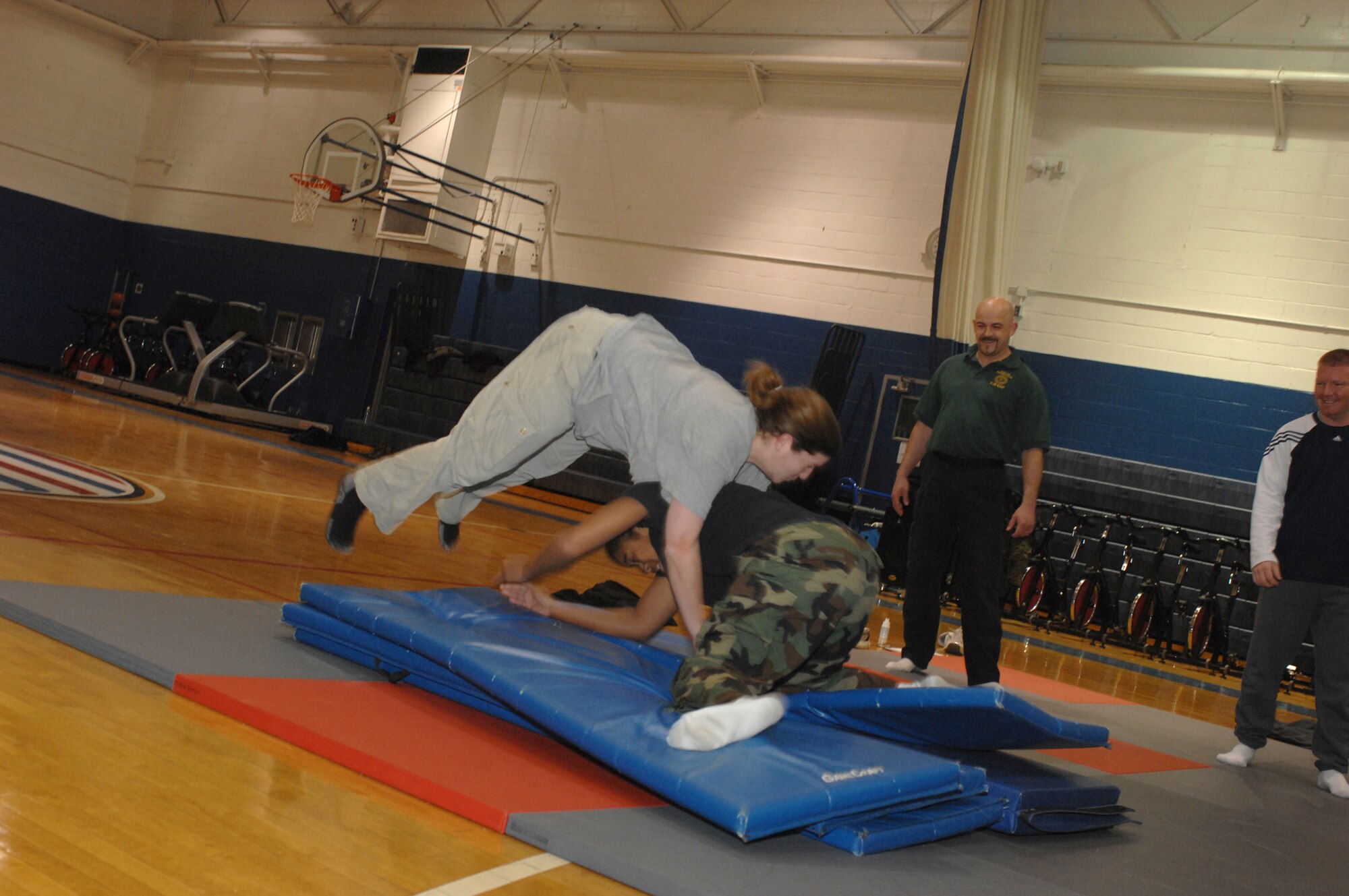 WHITEMAN AIR FORCE BASE, Mo. – Officer Mary Collins, Chenega Company, performs a "sprawl" techniques as Officer Lakeisha Carter, Chenega Company, attempts to grab her legs for a takedown at the fitness center Feb. 19. (U.S. Air Force photo/Tech. Sgt. Samuel A. Park)