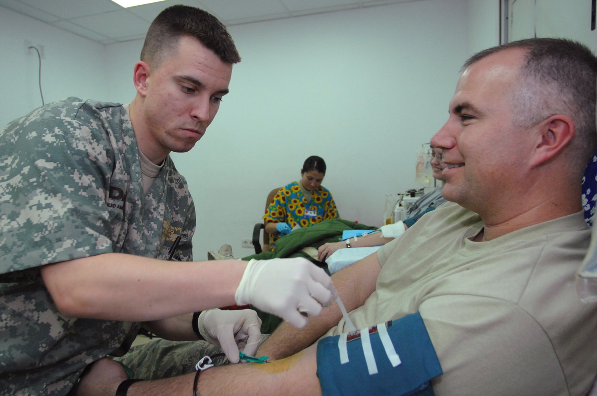 Army Spc. Lamar Elwell inserts a needle into the arm of Tech. Sgt. Jeff Ribelin before starting the platelet donation process Jan. 28 at the Air Force Theater Hospital at Balad Air Base, Iraq. The process of blood platelet donation differs from whole-blood donation because the patient is hooked up to a machine that processes the blood, extracting the red blood cells. The red blood cells are collected along with a small amount of blood plasma; the rest of the blood is returned to the patient with a small amount of anticoagulant agent. Specialist Elwell is a 153rd Blood Support Detachment medical lab technician deployed from Fort Lewis, Washington. Sergeant Ribelin is a 332nd Expeditionary Medical Support Squadron biomedical repair technician deployed from MacDill Air Force Base, Fla. (U.S. Air Force photo/Senior Airman Julianne Showalter) 