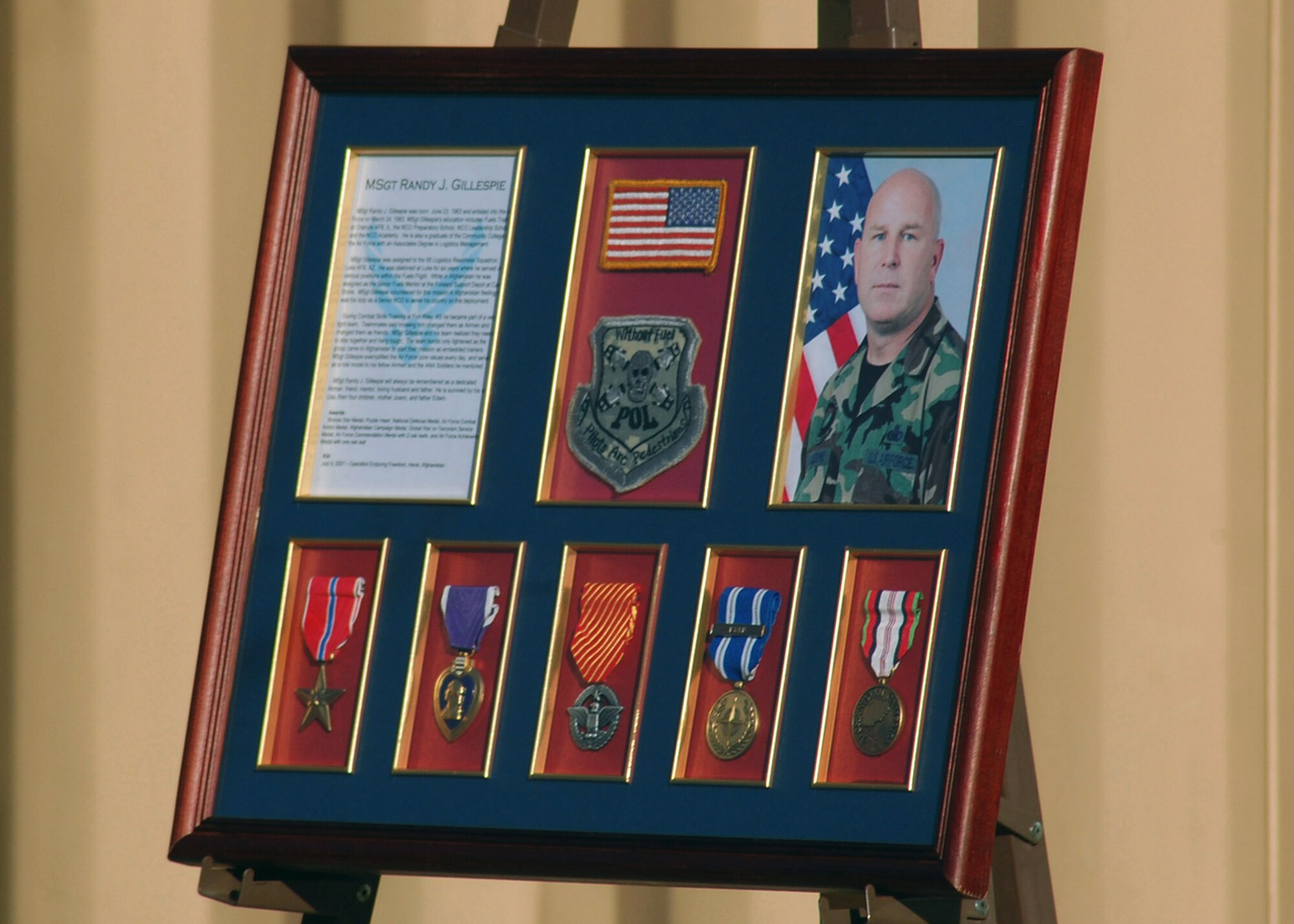 A plaque displaying Master Sgt. Randy Gillespie's biography and awards is unveiled during a dedication ceremony March 2 and will be placed in the hallway of the newly named Gillespie House at Camp Eggers, Afghanistan. Sergeant Gillespie was killed in action in July 2007 while serving as an embedded training team senior mentor with the Afghan national army 207th Corps in Herat. (U.S. Navy photo/Seaman Timothy Newborn) 
