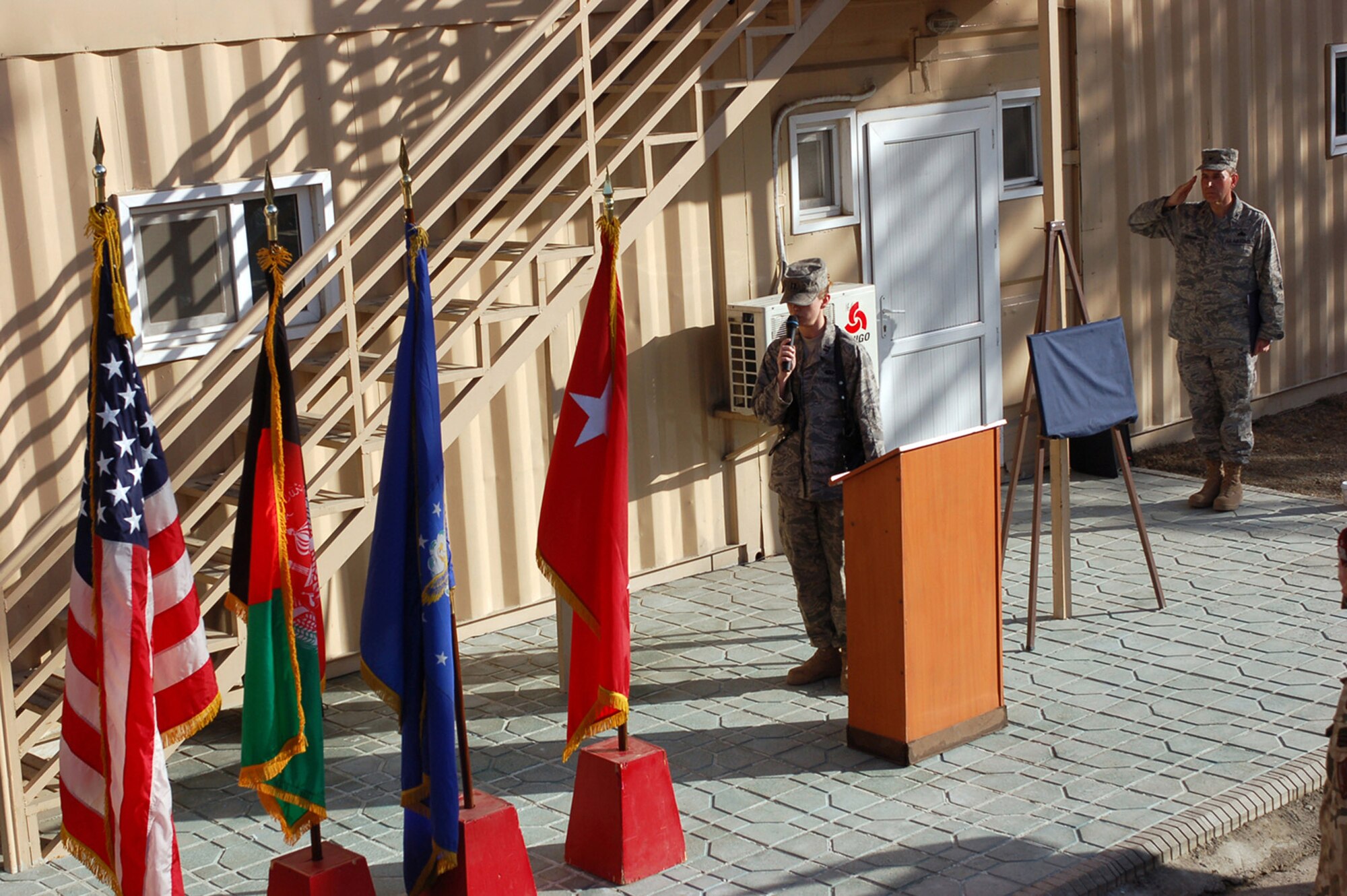 Capt. Jennifer Mack sings the national anthem during a memorial dedication to a fallen Airman March 2 at Camp Eggers, Afghanistan. Master Sgt. Randy Gillespie was killed in action in July 2007 while serving as an embedded training team senior mentor with the Afghan national army 207th Corps in Herat. Captain Mack is assigned to the Camp Eggers Morale, Welfare and Recreation Office. (U.S. Air Force photo/Staff Sgt. Robert Wollenberg) 