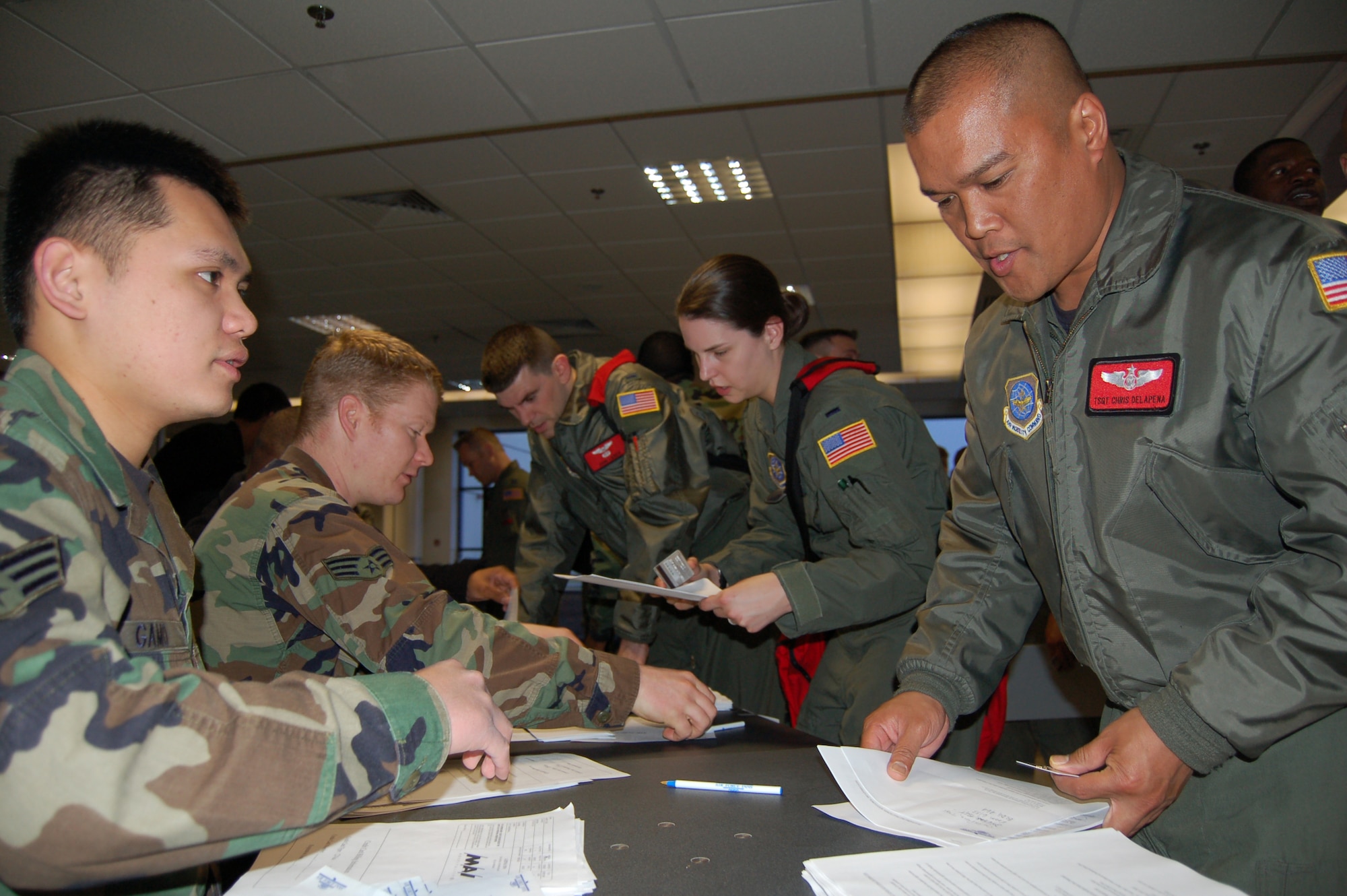 Senior Airmen Ron Gamo (left) and Steven Riley, 100th Services Squadron lodging clerks, hand out billeting assignments to deployed Airmen of the 817th Expeditionary Airlift Squadron at the RAF Mildenhall Passenger Terminal Feb. 26.  (From right to left) Tech. Sgt. Chris Delapena, 1st Lt. Amalee Thurber, and 1st Lt. John Lieber will call Mildenhall home for the next two months as the 10,000-foot runway at Incirlik Air Base, Turkey, undergoes extensive renovation.  (U.S. Air Force photo by Tech. Sgt. Eric Petosky)