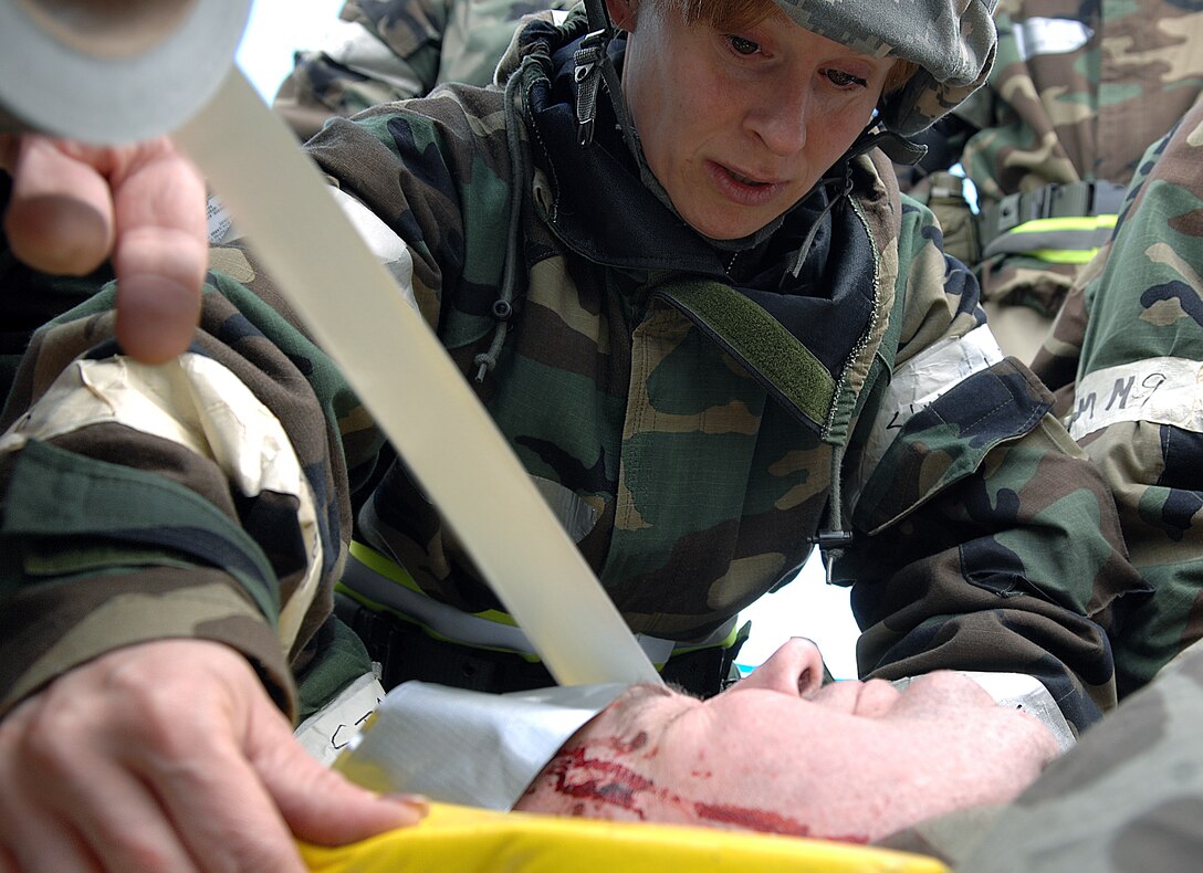 LANGLEY AIR FORCE BASE, Va. -- Master Sgt. Pam Browning, 1st Medical Group, stretches tape over the head of a simulated wounded patient during a Phase II Operational Readiness Exercise Feb. 27. Sergeant Browning and fellow Airmen successfully simulated escorting the patient to the hospital in a timely manner. During the exercise, Airmen were tested on their ability to survive and operate in a deployed environment. (U.S. Air Force photo/Senior Airman Vernon Young)