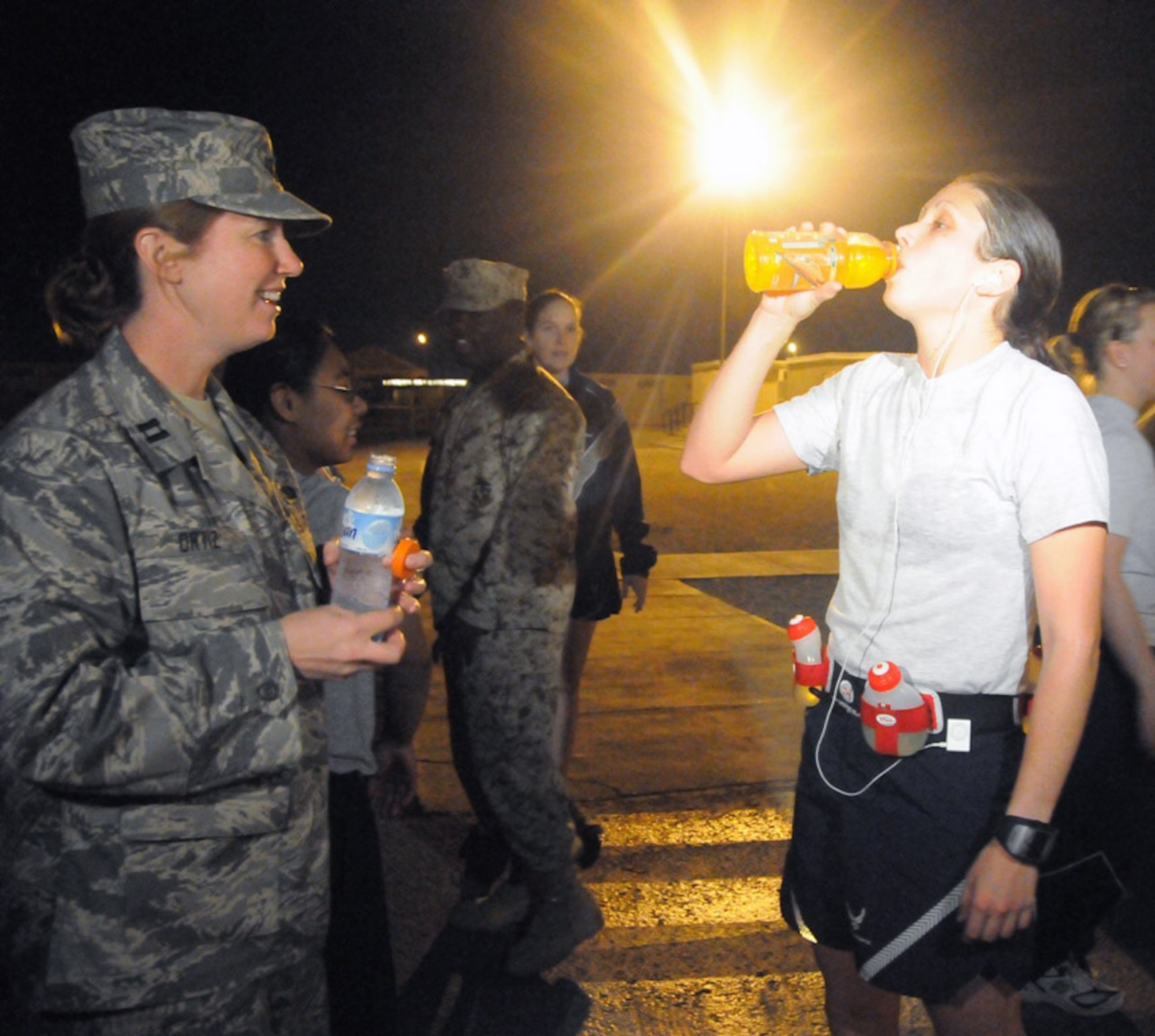 Capt. Meredith Ortiz provides 1st Lt. Jessica Lopez with a sports drink at the completion of the 26.2 mile run. As the event coordinator, Captain Ortiz enlisted the help of several volunteers to help plan and execute the marathon and 5K in just two weeks. (U.S. Air Force photo/Senior Airman Domonique Simmons) 