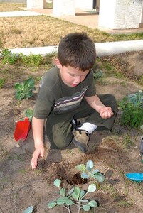 Toby Mills, 5, displays his gardening skills at the Randolph Child Development Center.