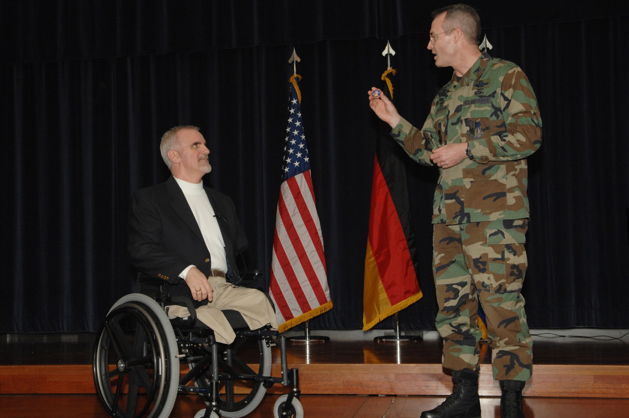 SPANGDAHLEM AIR BASE, Germany – Col. Darryl Roberson, 52nd Fighter Wing commander, presents a coin to Bob Mortimer, a motivational and ministry speaker, who spent time talking with Sabers and students on base Feb. 29, 2008. Mr. Mortimer lost both legs and an arm after being electrocuted following a car accident. He travels around the globe telling his story to help to encourage people and let them know that they can do great things. (U.S. Air Force photo/Senior Airman Logan Tuttle)