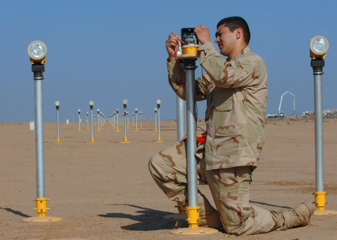 BALAD AIR BASE, Iraq -- Airman Nicholas Wengerd, 332nd Expeditionary Civil Engineer Squadron electrician, trouble shoots a strobe approach light here, Feb. 28. The strobe lights are used during foggy weather conditions to guide pilots in during landing operations. Airman Wengerd is deployed from Ellsworth Air Force Base, S.D. (U.S. Air Force photo/ Senior Airman Julianne Showalter)