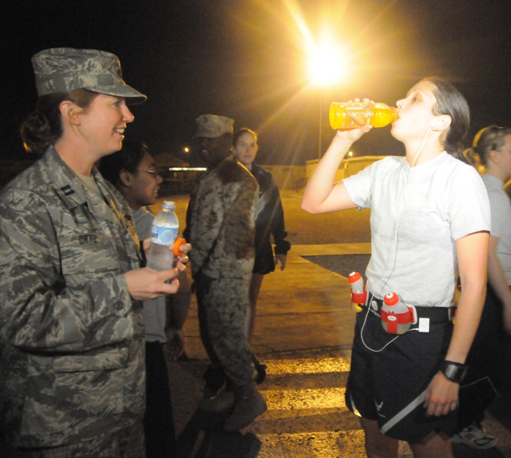 Capt. Meredith Ortiz provides 1st Lt. Jessica Lopez a sports drink at the completion of the 26.2 mile run.  As the event coordinator Captain Ortiz enlisted the help of several volunteers to help plan and execute the marathon and 5K in just two weeks. (U.S. Air Force photo/Senior Airman Domonique Simmons) 