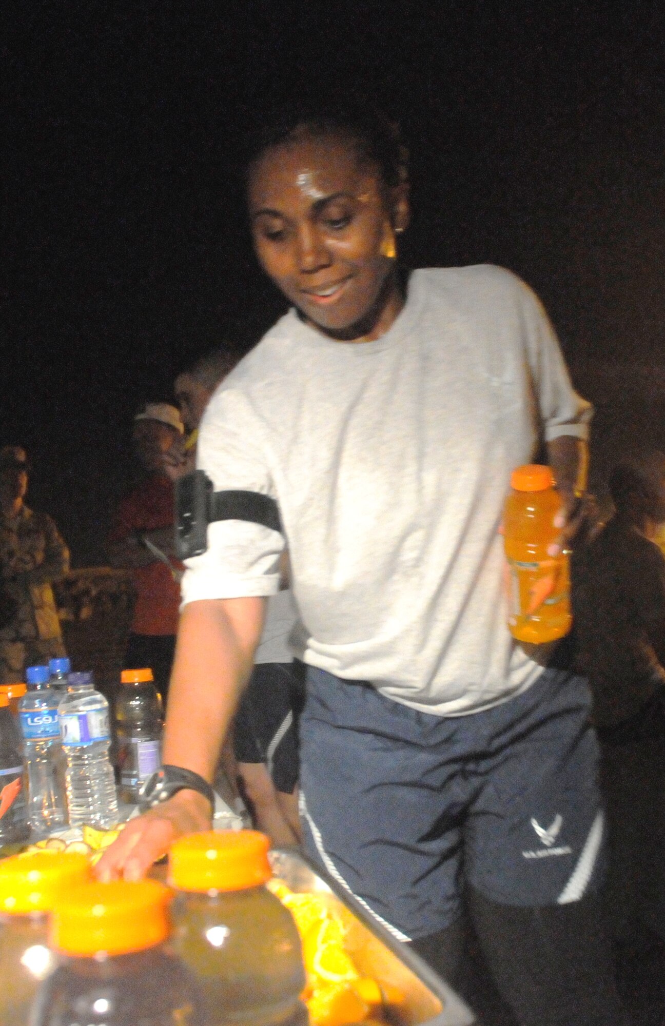 Staff Sgt. Lori Downey from the 379th Expeditionary Comptroller Squadron, grabs a few refreshments after the Women’s History Month 5K that was held in conjunction with the full marathon ran by 1st Lt. Jessica Lopez here March 2.  The refreshments were provided the 379th Expeditionary Services Squadron and distributed by volunteers. (U.S. Air Force photo/Senior Airman Domonique Simmons)