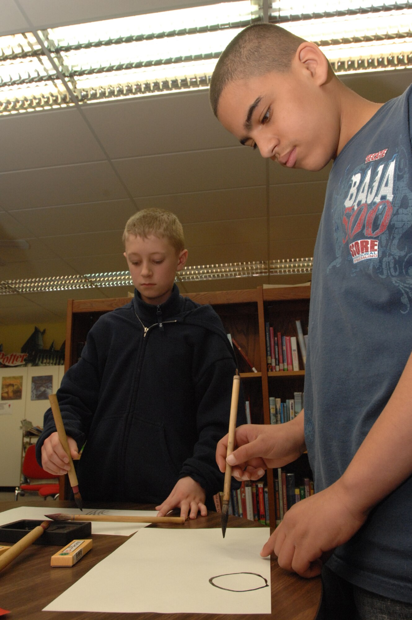 SPANGDAHLEM AIR BASE, Germany -- (Left to right) Quentin Pancake, son of Master Sgt. Nicholas Pancake, 52nd Fighter Wing, and Taylor Donalston, stepson of Master Sgt. Jack Elmo, 52nd Equipment Maintenance Squadron, paint pictures using the new calligraphy skills they learned. The students had the opportunity to learn calligraphy during the school’s A Day in Ancient China Feb. 27, 2008. (U.S. Air Force photo/Airman 1st Class Jenifer Calhoun)
