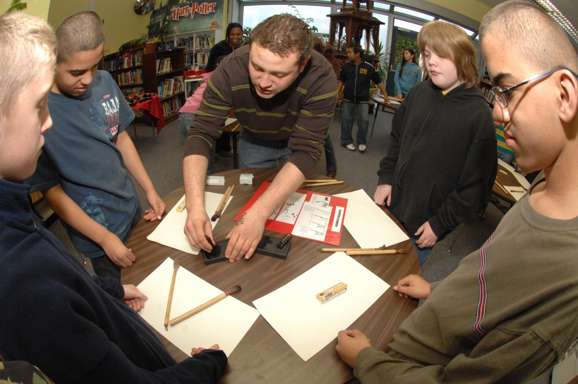 SPANGDAHLEM AIR BASE, Germany -- Senior Airman Vito Cipolla, 52nd Medical Group pharmacy, demonstrates how to blend ink in a rock as Spangdahlem Middle School students look on Feb. 27, 2008. The students had the opportunity to learn calligraphy during the school’s A Day in Ancient China. (U.S. Air Force photo/Airman 1st Class Jenifer Calhoun)