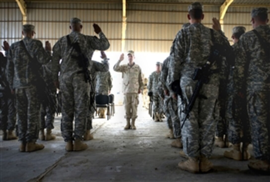 U.S. Navy Adm. Mike Mullen, chairman of the Joint Chiefs of Staff, reenlists soldiers from the 3rd Brigade Combat Team in Taji, Iraq, March 3, 2008. 