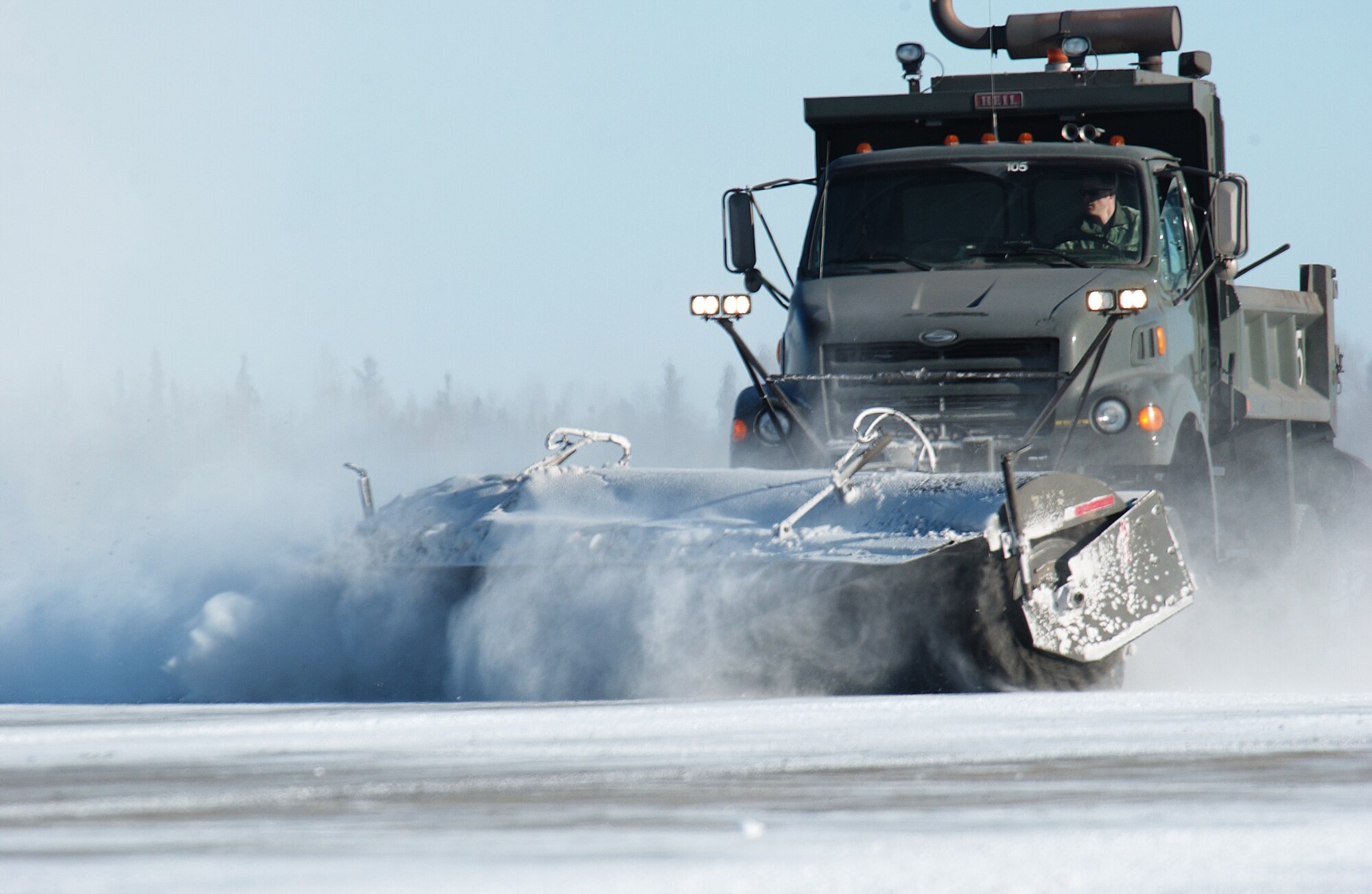 Airman 1st Class Tyler Kendhammer operates an airfield broom truck to clear the flight line of snow and ice Mar. 3 at Fort Wainwright, Alaska. Airmen of the 354th Civil Engineer Squadron horizontal construction flight aided nearby FWW in clearing the runway for C-17 Globemaster III and C-5 Galaxy aircraft to land and take off. The transports will deliver Soldiers and their equipment to the Joint Rreadiness Training Center at Fort Polk, La. to prepare them for deployments. Airman Kendhammer is a dirt boy with the 354th CES. (U.S. Air Force Photo/Airman 1st Class Jonathan Snyder)