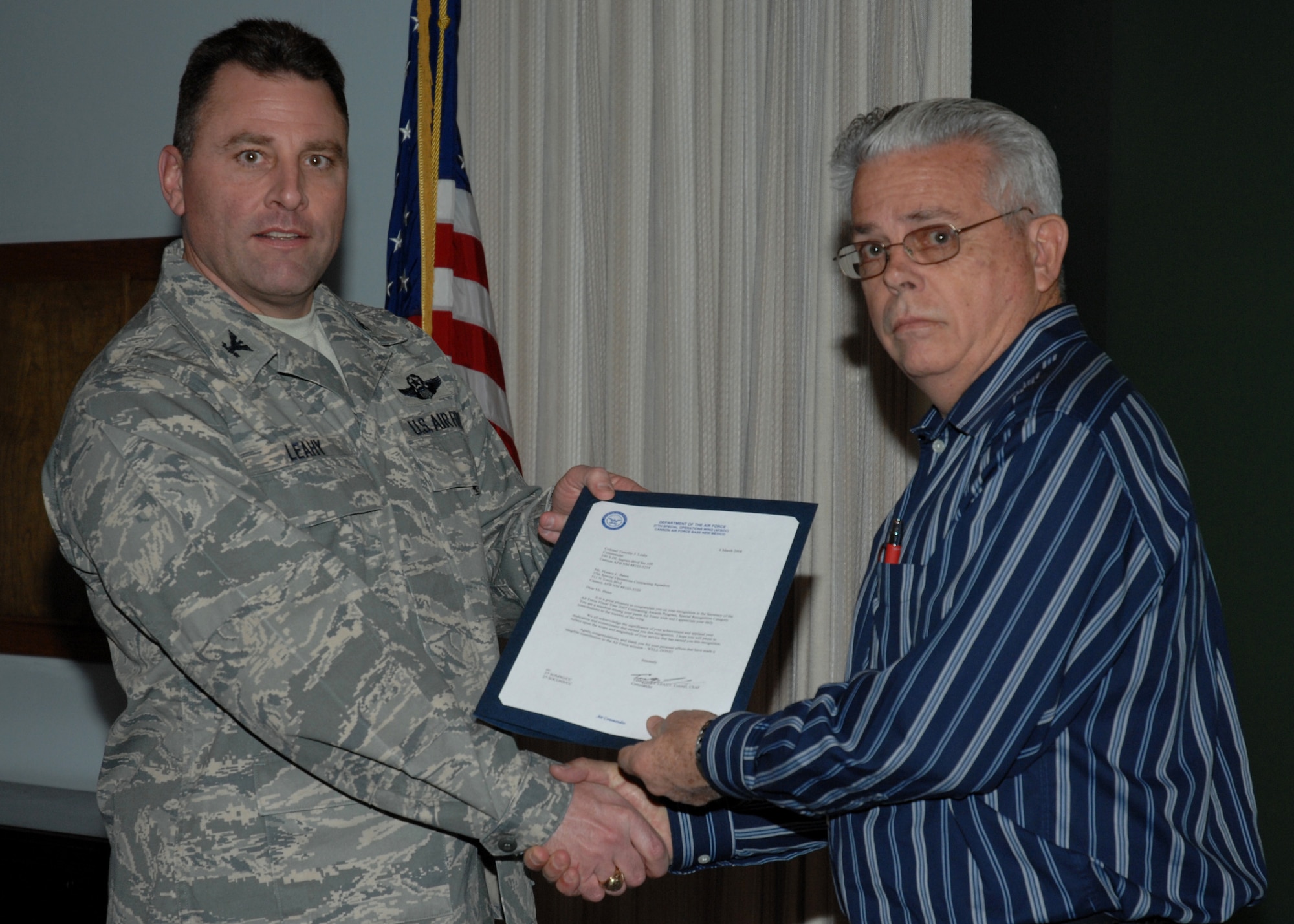 CANNON AIR FORCE BASE, N.M.-- Horace Bates receives the award for Special Recognition by Col. Timothy Leahy, 27th Special Operations Wing commander.  The presentation took place March 4 at wing headquarters during the weekly staff meeting. (U.S. Air Force photo/Airman 1st Class Evelyn Chavez)
