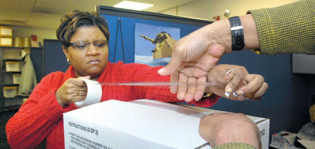 Marshell Johnson and Steve James tape a box of UPRGs in preparation for shipping to APFC where they will be scanned over the next couple months. Unit Personnel Record Groups are being relocated to Randolph Air Force Base to be scanned and made electronically available for all active duty personnel.  (US Air Force/SrA Renae Kleckner)