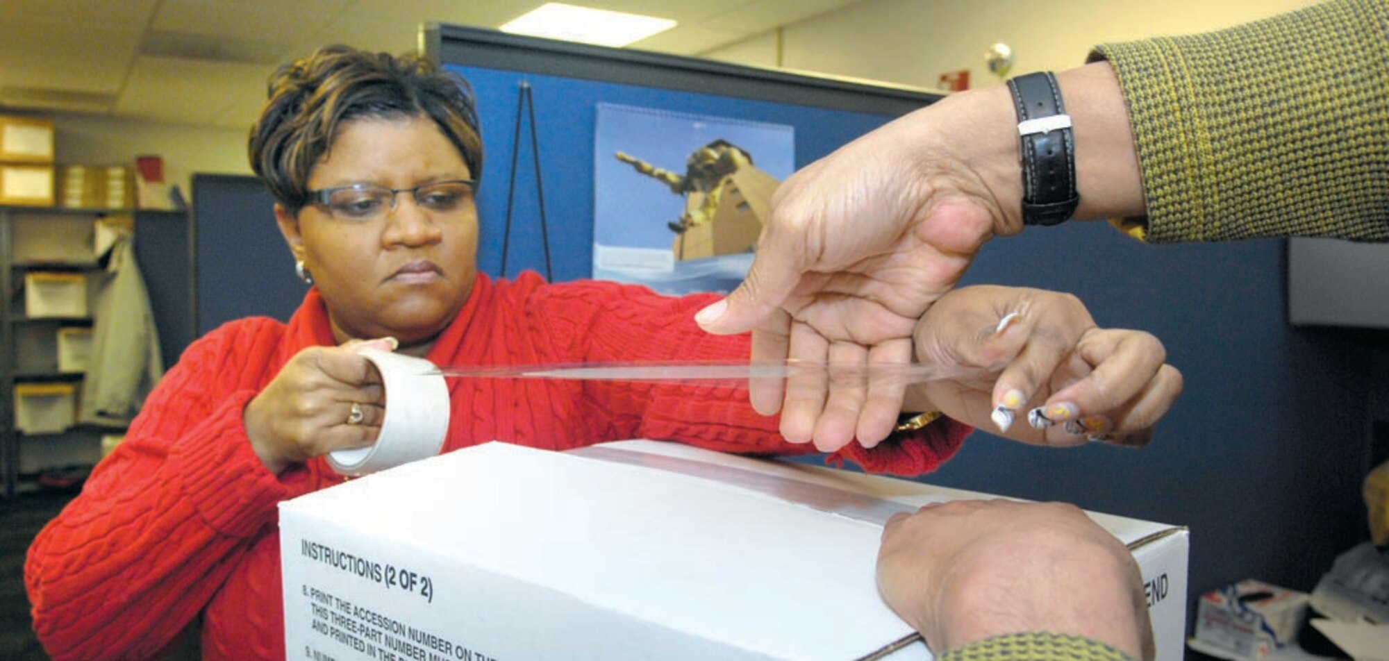 Marshell Johnson and Steve James tape a box of UPRGs in preparation for shipping to APFC where they will be scanned over the next couple months. Unit Personnel Record Groups are being relocated to Randolph Air Force Base to be scanned and made electronically available for all active duty personnel.  (US Air Force/SrA Renae Kleckner)