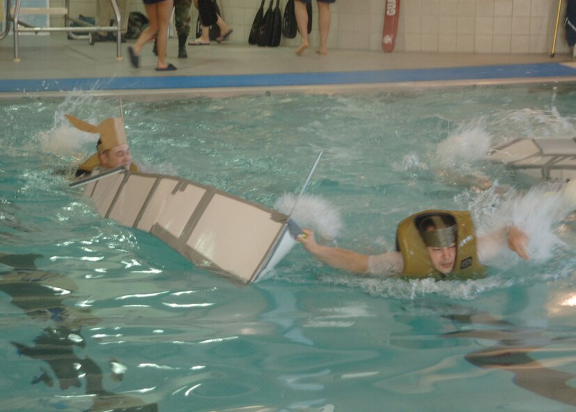 Senior Airmen David Adams and Isaiah Armstrong swim to the finish during the boat races at Winter Bash February 22.  Winter Bash is a annual event where base units and families compete in various events during the winter months of North Dakota. (U.S. Air Force photo/ Senior Airman Chad M. Kellum)