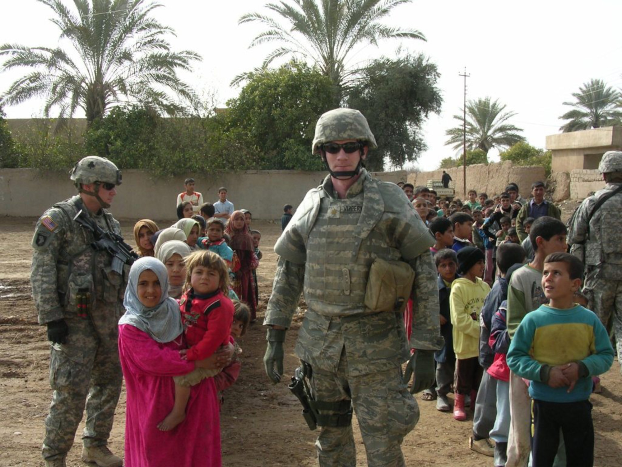 Maj. John Vipperman pauses with a group of Iraqi children during a humanitarian assistance mission Feb. 27 in the village of Kharagul, Iraq. Major Vipperman is the garrison engineer at Camp Anaconda, Iraq and is deployed from the 319th Civil Engineer Squadron, Grand Forks Air Force Base, N.D. (U.S. Army photo/Capt. Anthony Andreeko)