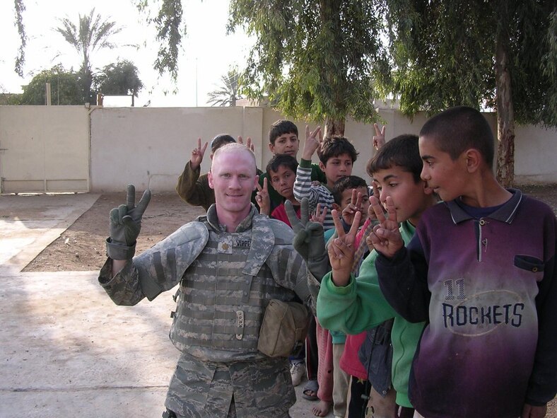 Maj. John Vipperman gives the sign for peace with Iraqi children during a humanitarian assistance mission Feb. 27 in the village of Kharagul, Iraq. Major Vipperman is the garrison engineer at Camp Anaconda, Iraq and is deployed from the 319th Civil Engineer Squadron, Grand Forks Air Force Base, N.D. (U.S. Army photo/Capt. Anthony Andreeko)