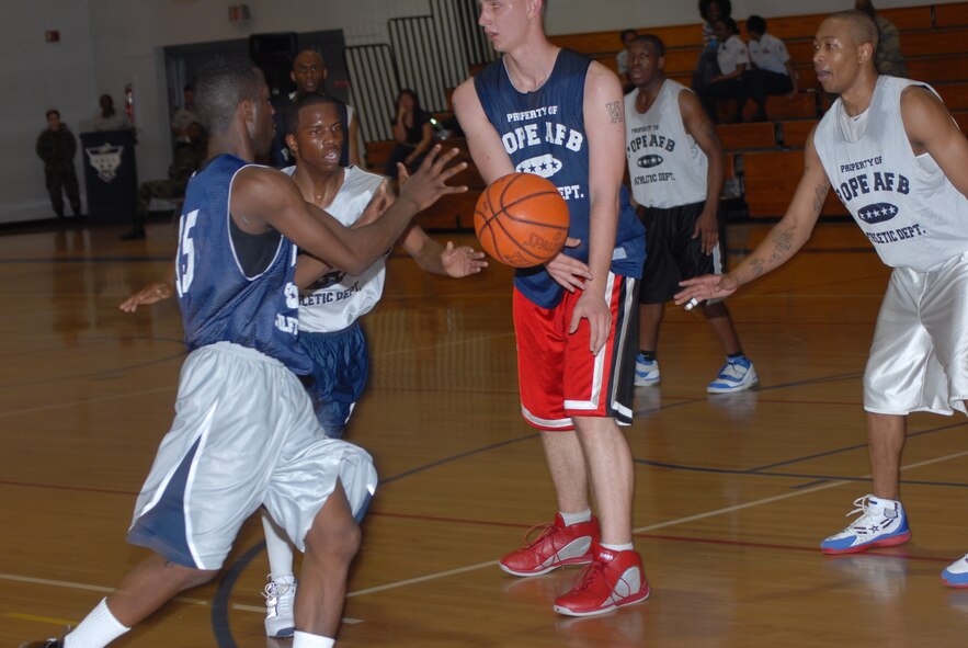 Irvin Gourdine, 43rd Mission Support Squadron, takes a no-look pass from Steven Morris, 43rd MSS, during the championship game March 3. (U.S. Air Force Photo by 2nd Lt. Chris Hoyler)