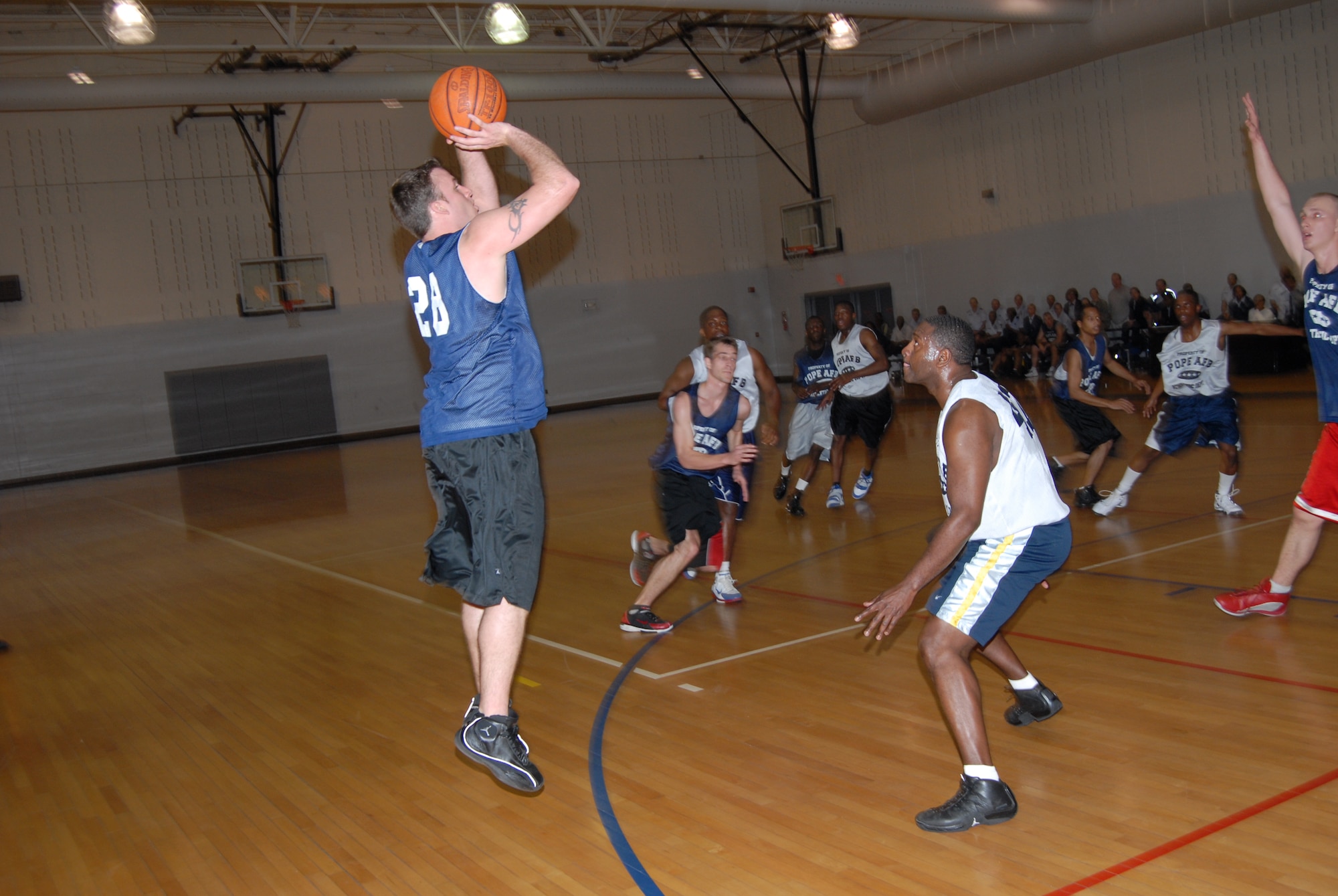 Kasey Crews, 43rd Mission Support Squadron, attempts a 3-pointer over Dobie Strong, 43rd Logistics Readiness Squadron, during the championship game March 3. (U.S. Air Force Photo by 2nd Lt. Chris Hoyler)