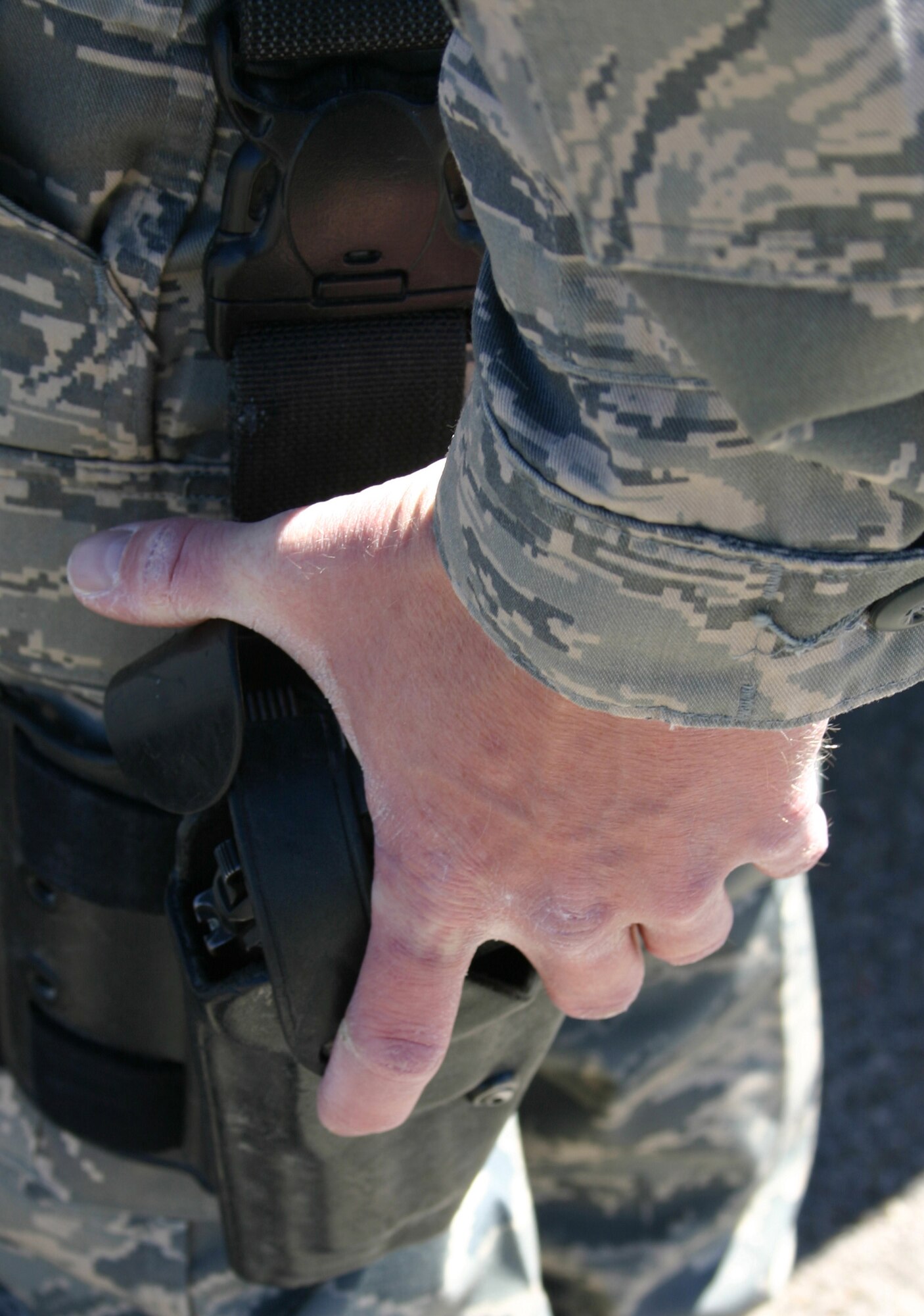 CANNON AIR FORCE BASE, N.M. - Senior Airman Mark Maddon, 27th Special Operations Security Forces Squadron, grips his sidearm holster while on duty. Airman Maddon has been selected to play keyboards with the Air Force's Tops in Blue during their 2008 world tour. (U.S. Air Force photo by Airman 1st Class Elliott Sprehe)
