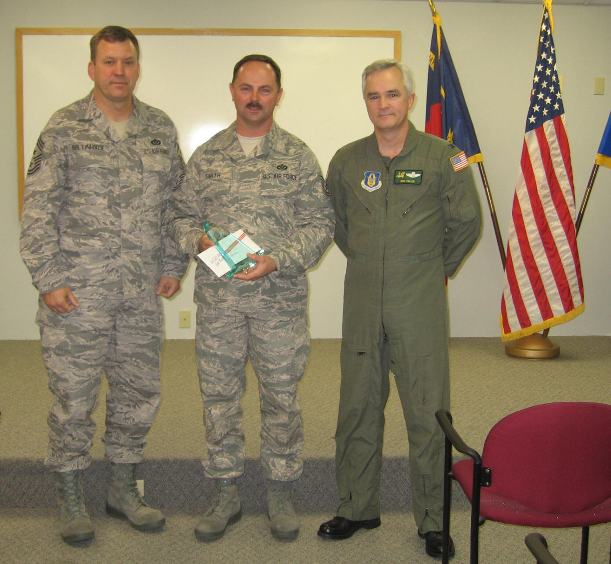 SEYMOUR JOHNSON AIR FORCE BASE, N.C. -- Tech. Sgt. Gary Smith (center) receives Non-commissioned Officer of the Quarter award from Command Chief Master Sgt. Lester Boltinhouse (left) and Col. Phil Fallin (right), 916th Air Refueling Wing vice-commander. Sergeant Smith is a heavy equipment craftsman with the 916th Civil Engineer Squadron.