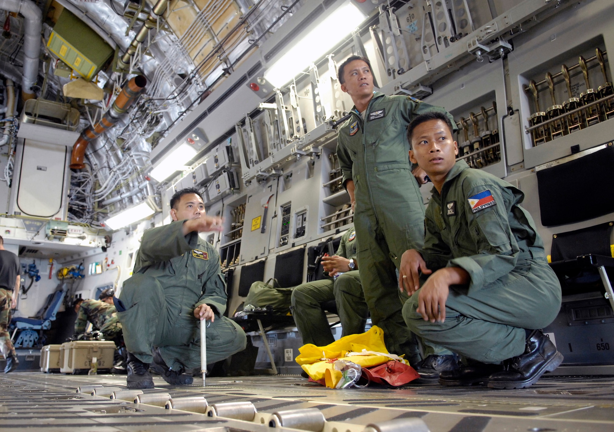 Master Sgt. Joseph Salvador explains the working of the C-17 Globemaster III to members of the Philippine air force prior to taking off on a mission Feb. 27 from Clark Field, Philippines, during Exercise Balikatan '08. Sergeant Salvador is a loadmaster from the Hawaii Air National Guard's 204th Airlift Squadron. Balikatan is an annual joint and bilateral exercise involving U.S. military and Philippines armed forces members. Subject matter experts from the Philippine Civil Defense Agencies and observers from Australia, Indonesia, Malaysia, Brunei, Thailand and Singapore work on humanitarian and disaster relief efforts. (U.S. Air Force photo/Tech. Sgt. Shane A. Cuomo) 