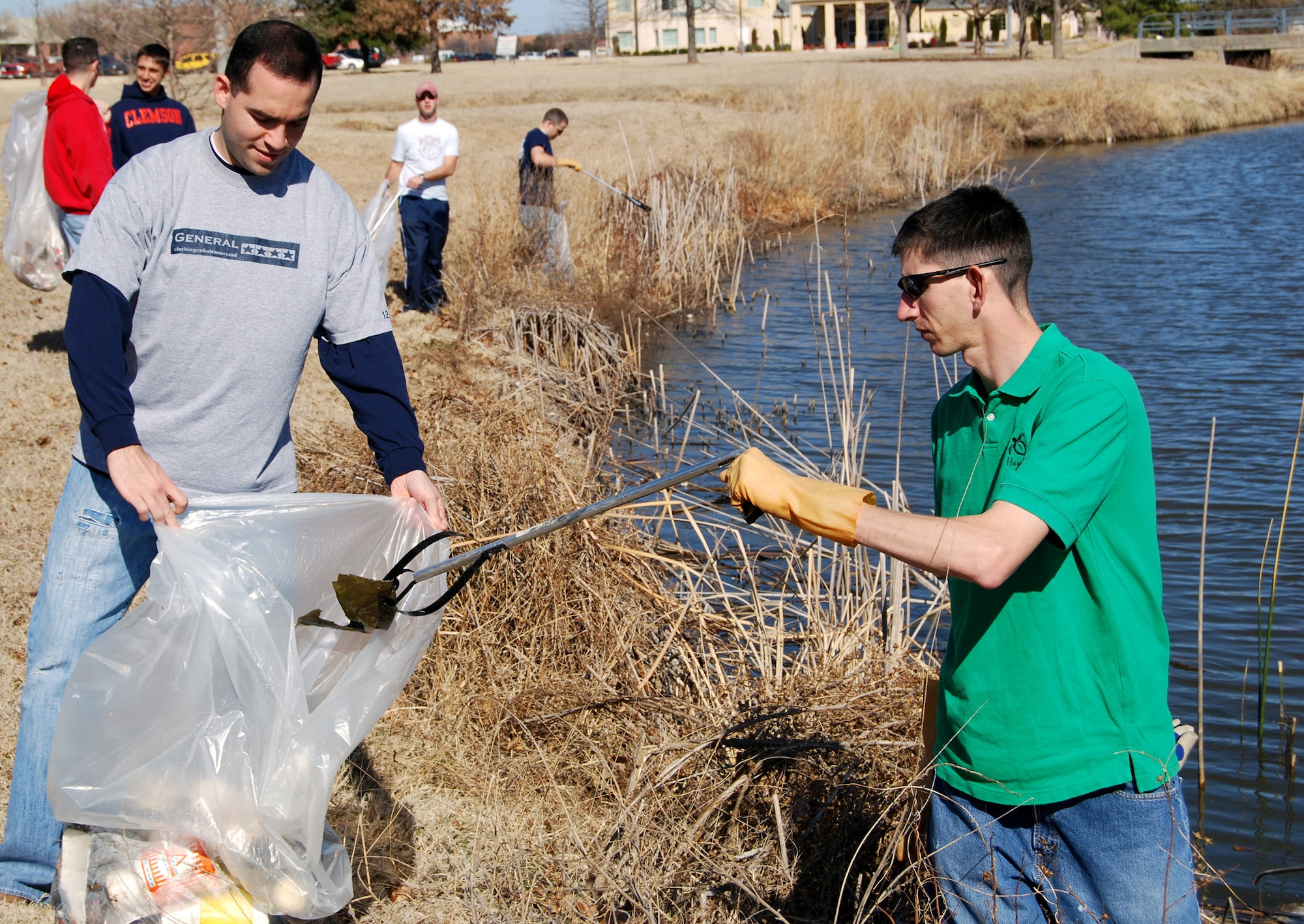 Second Lt. Steven Montalvo, left, and Capt. Peter Moughan, both from the 80th Operations Support Squadron, team up Feb. 29 to help clean up Quail Creek that feeds into Sikes Lake near Midwestern State Univeristy in Wichita Falls, Texas. Members of the 80th OSS get out once a month to perform a community service in one of Sheppard Air Force Base's surrounding cities. (U.S. Air Force photo/Mike McKito)