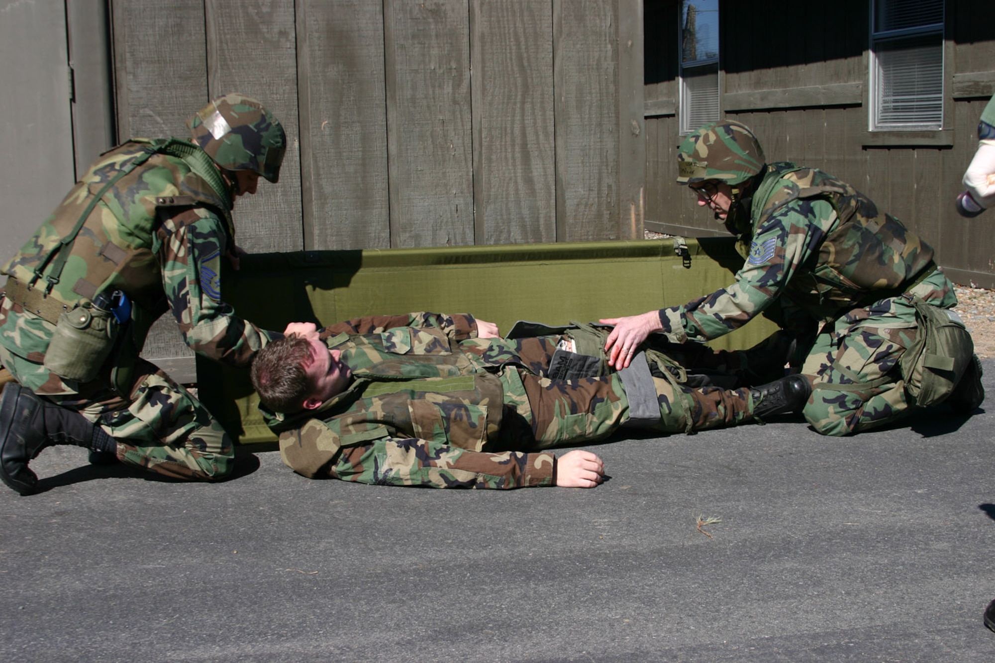 Master Sgt. Benjamin Tice (left) and Tech. Sgt. Nicholas DeGuire administer self-aid and buddy care to a fellow Airman with a broken leg during the practice exercise March 1. (U.S. Air Force photo by Airman 1st Class Kayla K. Edwards)
