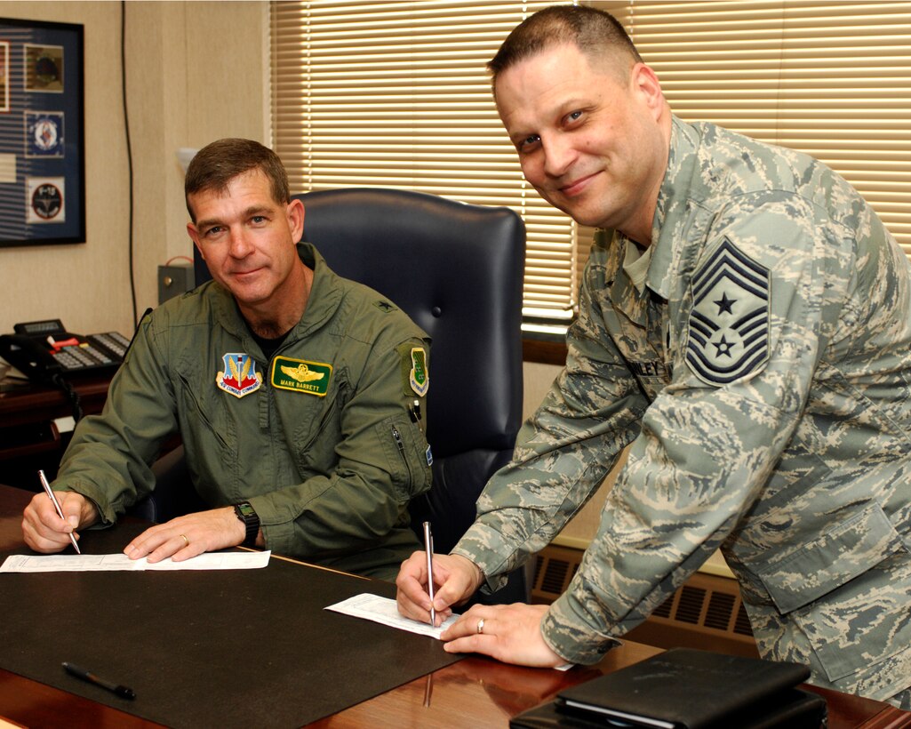LANGLEY AIR FORCE BASE, Va. – Brig. Gen. Mark Barrett, 1st Fighter Wing commander and Chief Master Sgt. James MacKinley, 1st FW command chief, sign their 2008 Air Force Assistance Fund campaign forms here March 3. The campaign, “Commitment to Caring,” will run from March 10 to May 3. People wishing to donate should contact their unit project officer. (U.S. Air Force photo/Airman Gul Crockett)

