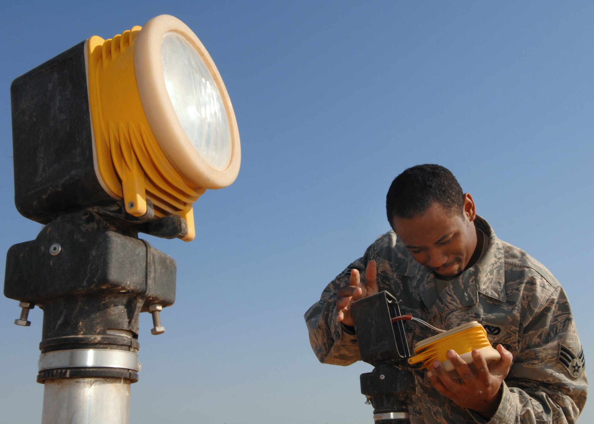 Senior Airman Travis Morehead troubleshoots an approach light Feb. 28 at Balad Air Base, Iraq. These lights aid landing by illuminating the runway. Airman Morehead, a 332nd Expeditionary Civil Engineer Squadron electrician, is deployed from Malmstrom Air Force Base, Mont. (U.S. Air Force photo/Senior Airman Julianne Showalter) 
