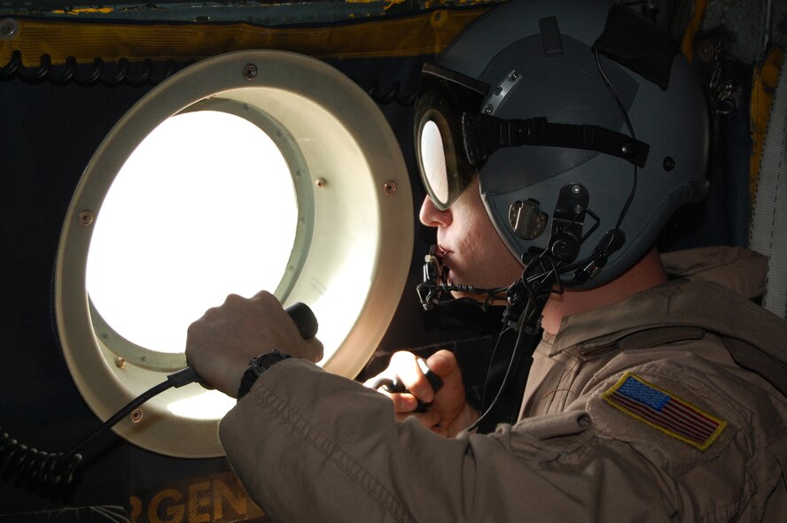 SOUTHWEST ASIA -- Staff Sgt. John Columbia, a loadmaster with the 737th Expeditionary Airlift Squadron, sits in the ready position at a troop passenger door of a C-130 Hercules during a recent mission over an Iraqi province. Sergeant Columbia sits ready to manually dispense chaff/flare if primary means do not function automatically when fired upon. The mission is part of leaflet air drop mission supporting the Australians from Overwatch Battle Group [West]-4 in southern Iraq. Sergeant Columbia is deployed from Ramstein Air Base, Germany, in support of Operations Enduring and Iraqi Freedom. (U.S. Air Force photo/1st Lt. Brock Burkhardt)