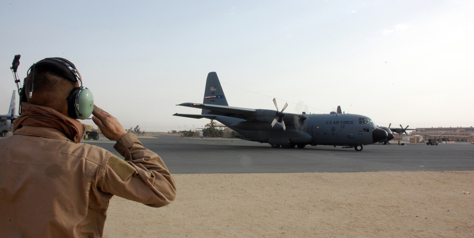 SOUTHWEST ASIA -- Airman 1st Class Buddy Bewick, 386th Expeditionary Aircraft Maintenance Squadron salutes the aircraft commander of a C-130 Hercules at a Southwest Asia air base recently. The mission is part of leaflet air drop mission supporting the Australians from Overwatch Battle Group [West]-4 in southern Iraq. Airman Bewick is deployed from Dyess Air Force Base, Texas, in support of Operations Enduring and Iraqi Freedom. (U.S. Air Force photo/Tech. Sgt. Michael O’Connor)