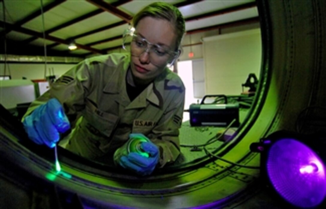 U.S. Air Force Senior Airman Rebeca Hill puts fluorescent fluid on the engine exhaust cover of an F-16 Fighting Falcon to find any cracks, Feb. 21, 2008, at Balad Air Base, Iraq. 