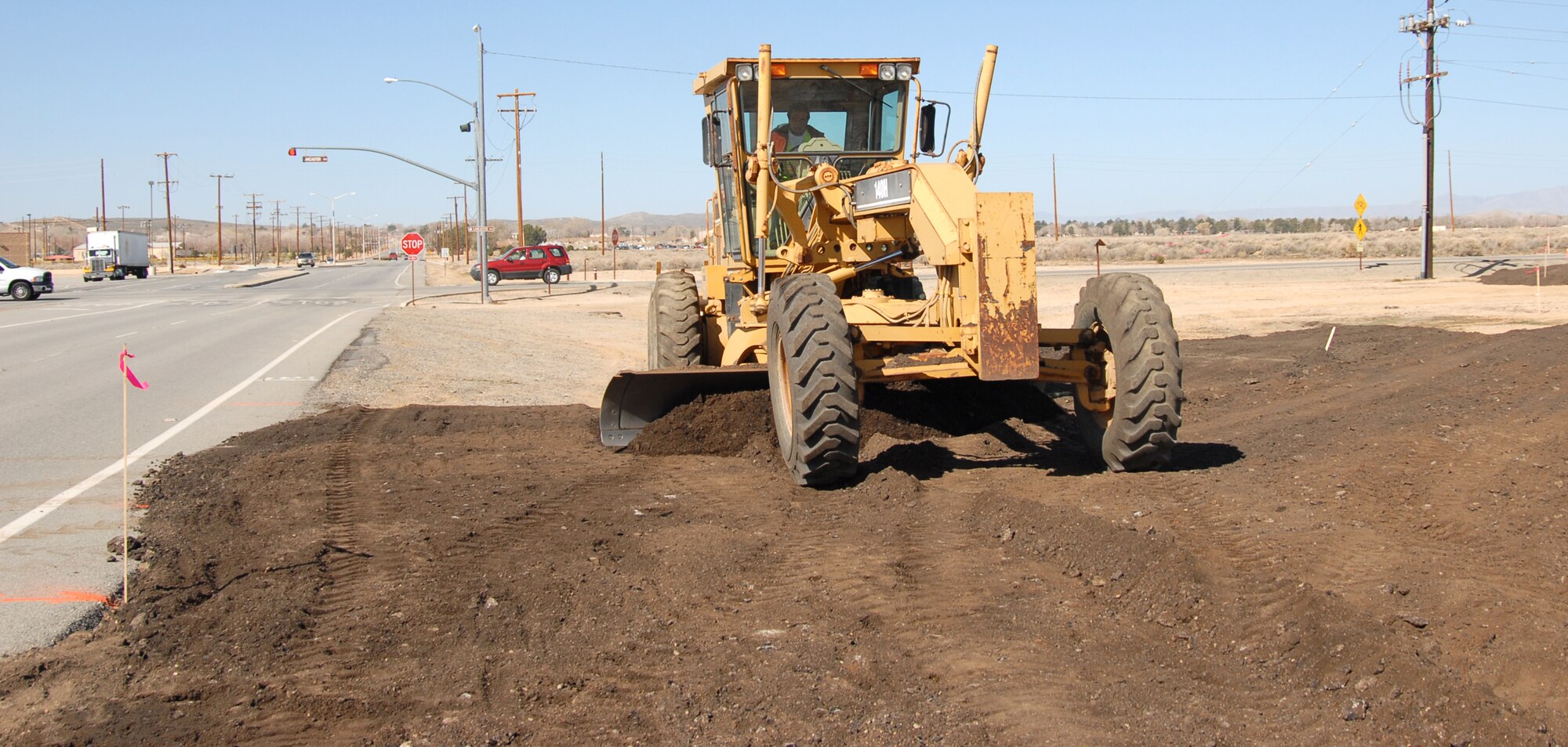 EDWARDS AIR FORCE BASE, Calif. -- Fernando Flores, a civilian contractor, uses a grader to make a bypass at the intersections of Lancaster and FitzGerald boulevards March 5. The bypasses at the intersections of both Lancaster and FitzGerald boulevards and Rosamond and FitzGerald boulevards are being built as part of a road construction project to replace both intersections' asphalt pavement with concrete. Construction on the Rosamond and FitzGerald boulevards intersection is set to begin March 10.  (Air Force Photo By Airman 1st Class William O'Brien)