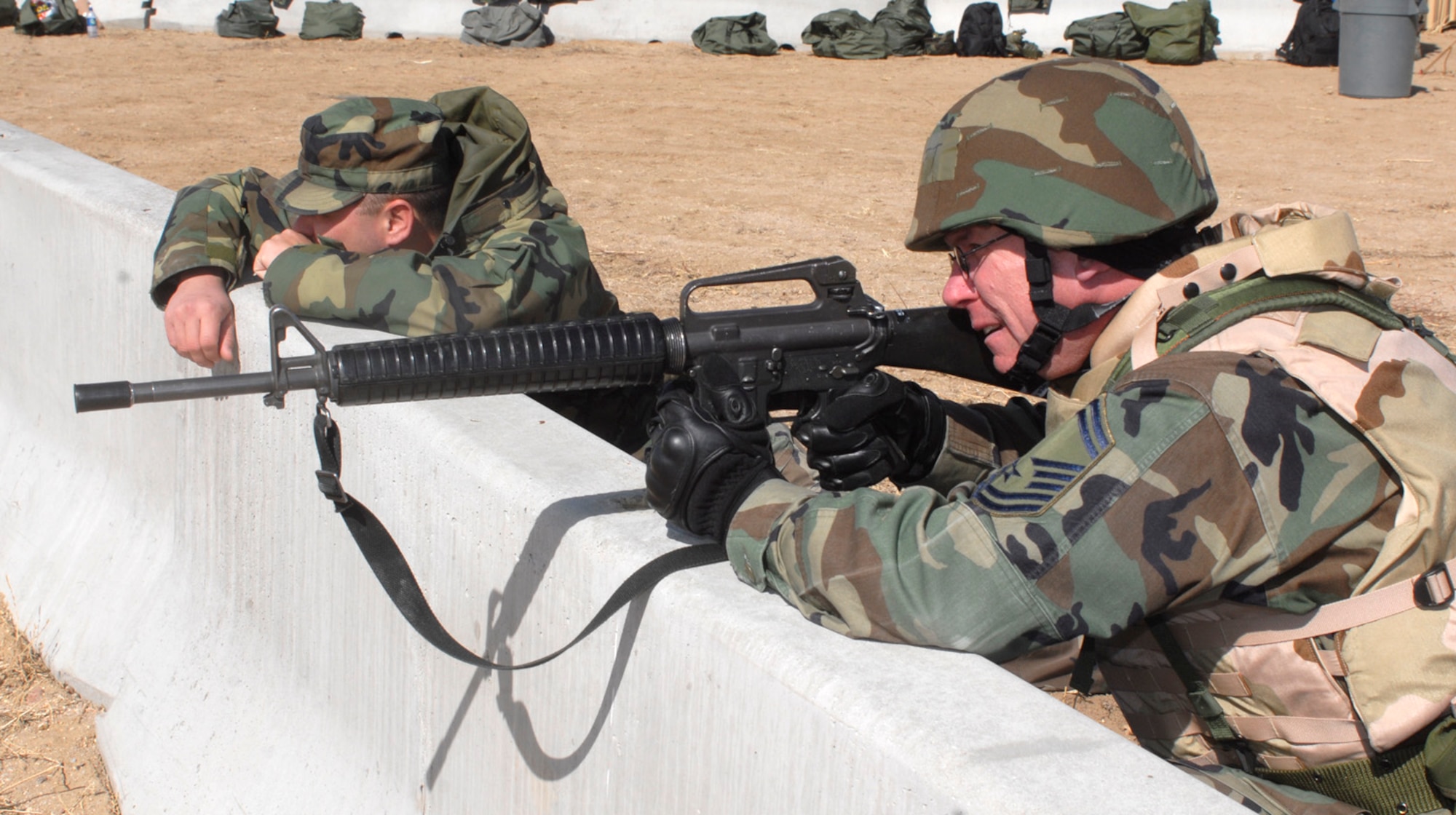 Manning his post, Senior Master Sgt. Harvey Kraft simulates preparing to defend his defensive fighting position from insurgents during Peterson's first Deployment-Ready Expeditionary Skills Training, or 'DREST.' Sergeant Kraft is assigned to the 21st Mission Support Squadron. (U.S. Air Force photo/Larry Hulst)