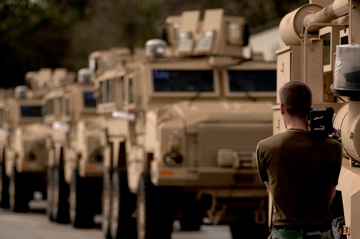 Staff Sgt. Robert Sizelove videotapes Mine Resistant Ambush Protected vehicles parked on the Charleston AFB flightline Tuesday. Sergeant Sizelove is a broadcaster with the 437th Airlift Wing Public Affairs office on Charleston AFB.  (U.S. Air Force Photo/Senior Airman Nicholas Pilch)