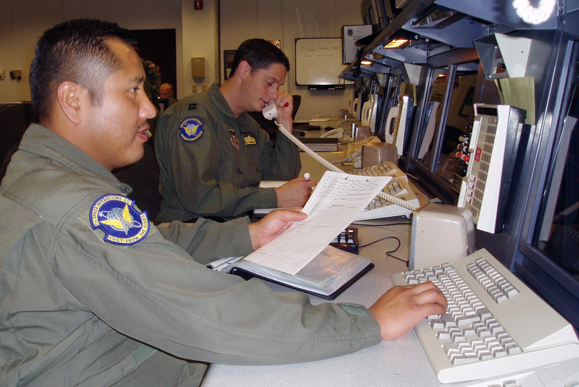 Tech. Sgt. Juan Gutierrez (left) and Capt. Garrett Donnelly, both of the 7th Space Operations Squadron, check on the status of a satellite to ensure it is operating within normal parameters.  They are among the reservists who will become part of the new 310th Space Wing when it is activated March 7 at Schriever Air Force Base, Colo.  (U.S. Air Force photo)