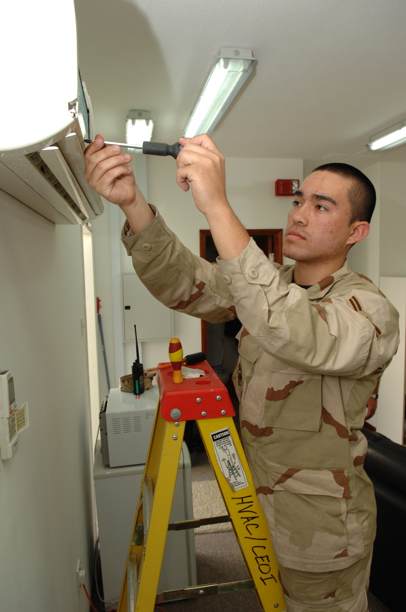 Airman 1st Class Dennis Villegas, 380th Expeditionary Civil Engineer Squadron Heating, Ventilating and Air Conditioning technician, disassembles an air conditioning unit in a 380th Air Expeditionary Wing dormitory in Southwest Asia, Feb. 7. Throughout his life, Airman Villegas has live in Bolivia, Chile, Brazil, the United States of America and is now supporting operations Iraqi and Enduring Freedom in Southwest Asia. He is deployed from McGuire AFB, N.J. (U.S. Air Force photo/Senior Airman Levi Riendeau)