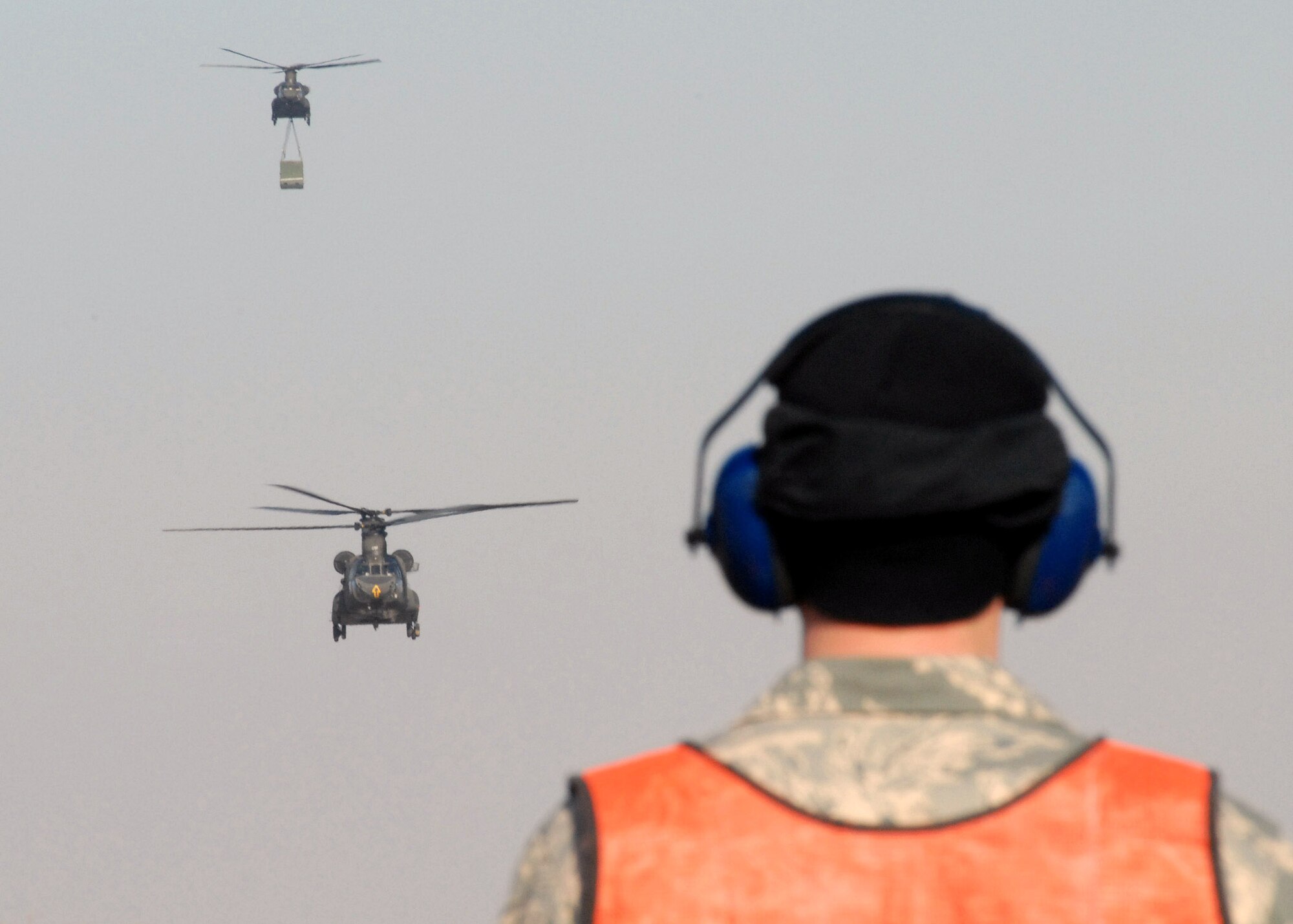Senior Airman Paul Epping stands by to marshal two CH-47 Chinook helicopters as they arrive March 1at Kunsan Air Base, South Korea.  The Chinook's arrived from Camp Humphrey's, Bravo Company 4-2, as part of the Key Resolve/Foal Eagle Exercise, enhancing combat readiness and joint interoperability. Airman Epping is a crew chief from the 8th Maintenance Squadron. (U.S. Air Force Photo/Staff Sgt. Araceli Alarcon) 