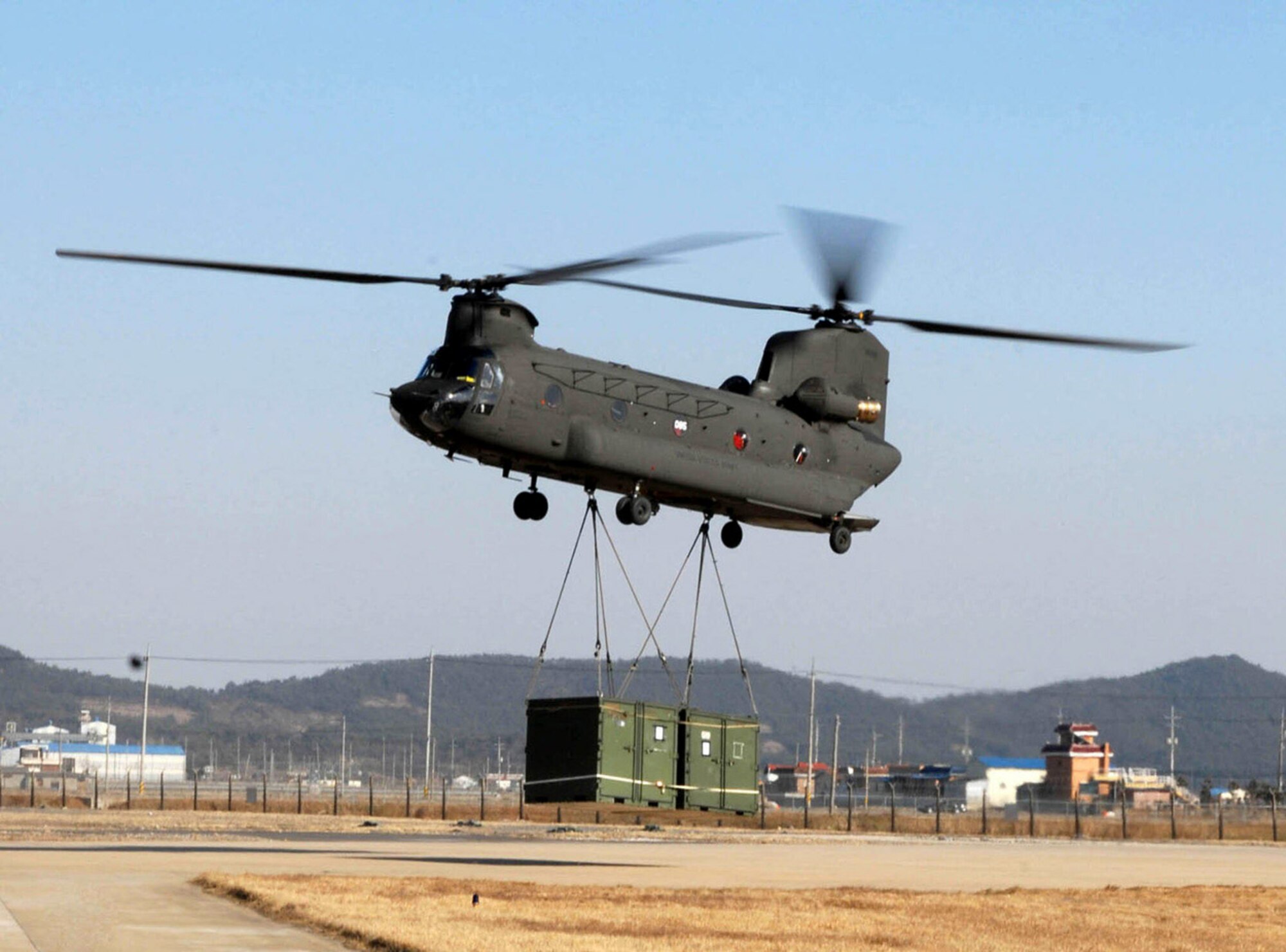 A CH-47 Chinook helicopter drops off troops, vehicles and additional supplies March 1 at Kunsan Air Base, South Korea. The Chinook arrived from Camp Humphrey's, Bravo Company 4-2, as part of the Key Resolve/Foal Eagle Exercise, enhancing combat readiness and joint interoperability. (U.S. Air Force photo/Senior Airman Steven R. Doty) 

