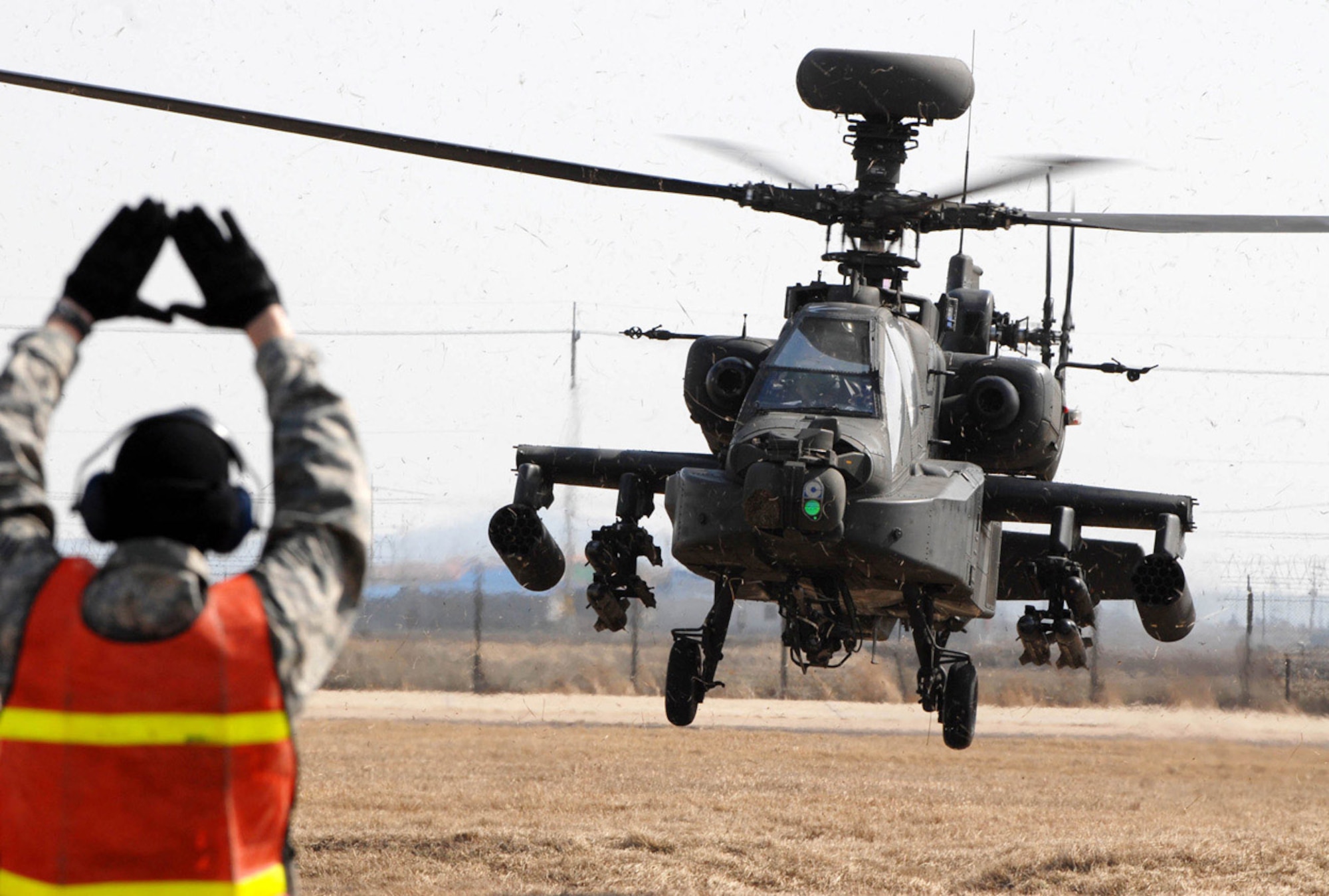 Senior Airman Paul Epping marshal's an AH-64 Apache helicopter March 1 at Kunsan Air Base, South Korea. The Apache's arrived from Camp Humphrey's, Bravo Company 4-2, as part of the Key Resolve/Foal Eagle Exercise, enhancing combat readiness and joint interoperability. Airman Epping is a crew chief from the 8th Maintenance Squadron. (U.S. Air Force photo/Senior Airman Steven R. Doty) 