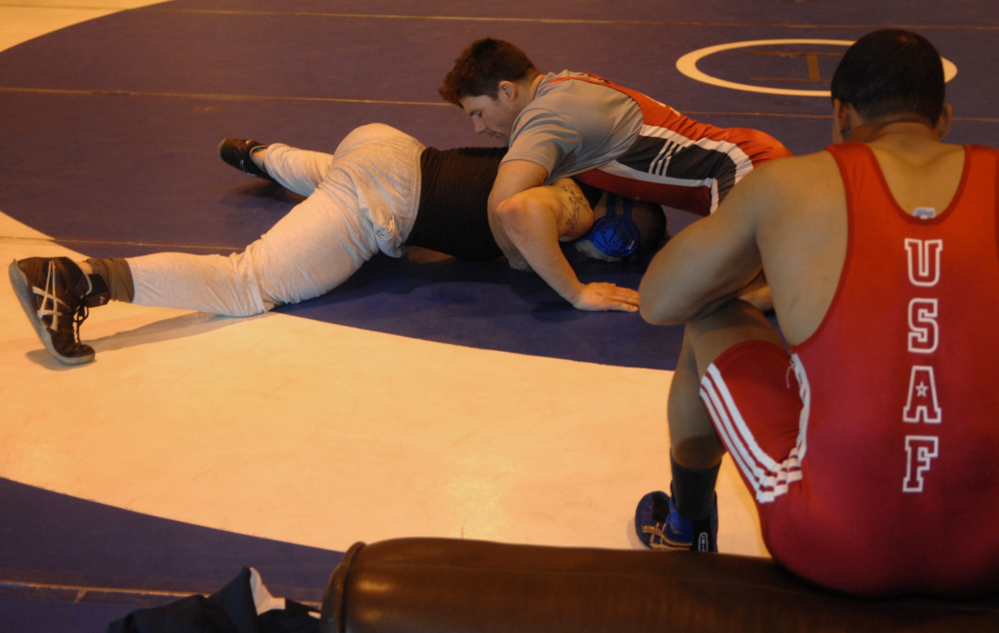 MOUNTAIN HOME AIR FORCE BASE, Idaho -- Left, Nader Maghribe, Travis AFB, Calif., and Brett Spangler, Schriever AFB, Colo., practice their wrestling moves at the fitness center here March 5 while Peter Hicks, Peterson AFB, Colo., gives them pointers. Beginning Feb. 13, almost two dozen potential candidates for the All Air Force Wrestling Team began tryouts for the 2008 wrestling season. After more than 120 candidates sent applications to Richard Estrella, the Air Force wrestling coach for 21 years, he chose the 13 most-talented athletes to join the team. (U.S. Air Force photo/Airman 1st Class Stephany Miller)