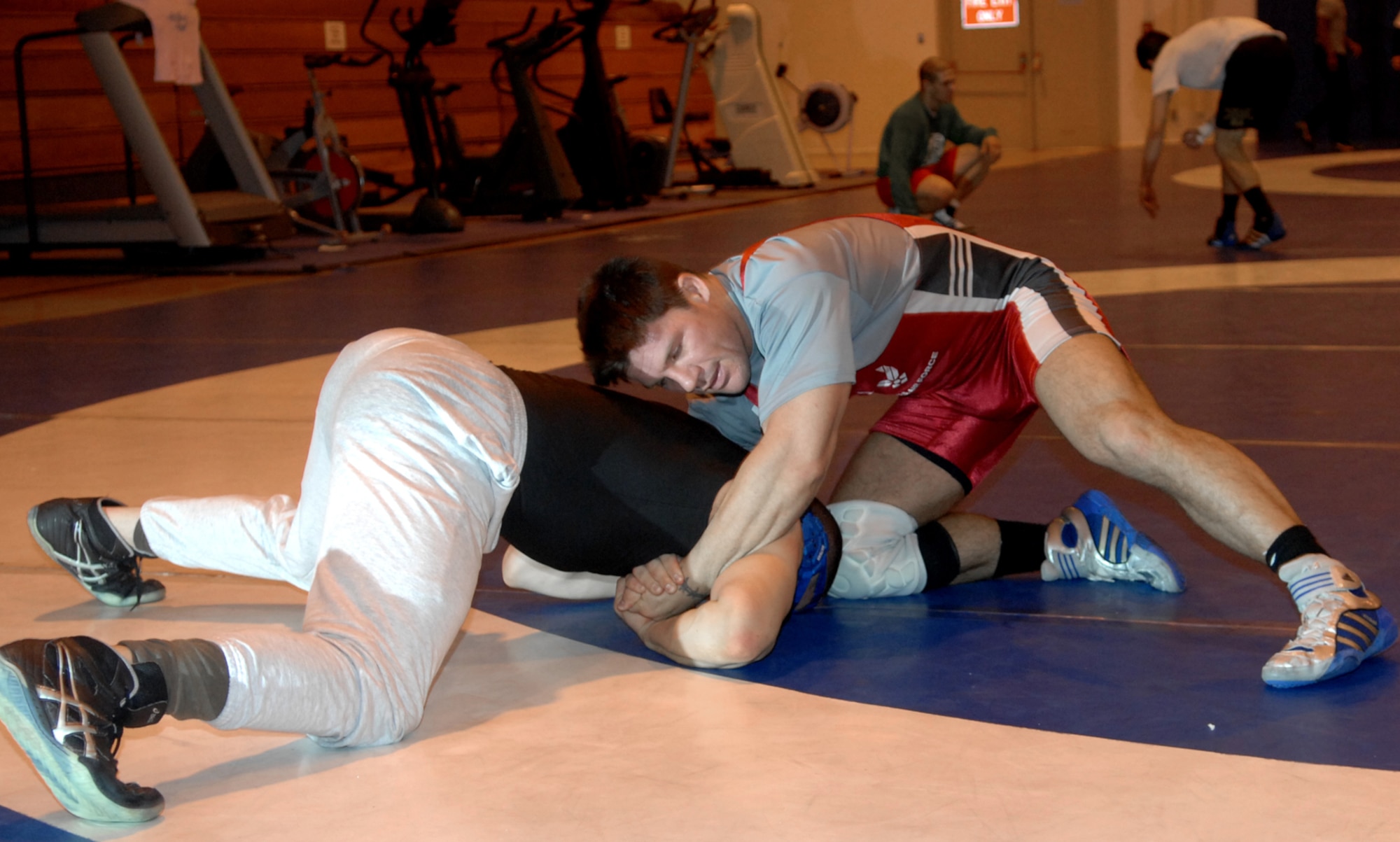 MOUNTAIN HOME AIR FORCE BASE, Idaho -- Left, Nader Maghribe, Travis AFB, Calif., and Brett Spangler, Schriever AFB, Colo., practice their wrestling moves in preparation for the Armed Forces Championship at the fitness center here March 5. Beginning Feb. 13, almost two dozen potential candidates for the All Air Force Wrestling Team began tryouts for the 2008 wrestling season. After more than 120 candidates sent applications to Richard Estrella, the Air Force wrestling coach for 21 years, he chose the 13 most-talented athletes to join the team. (U.S. Air Force photo/Airman 1st Class Stephany Miller)