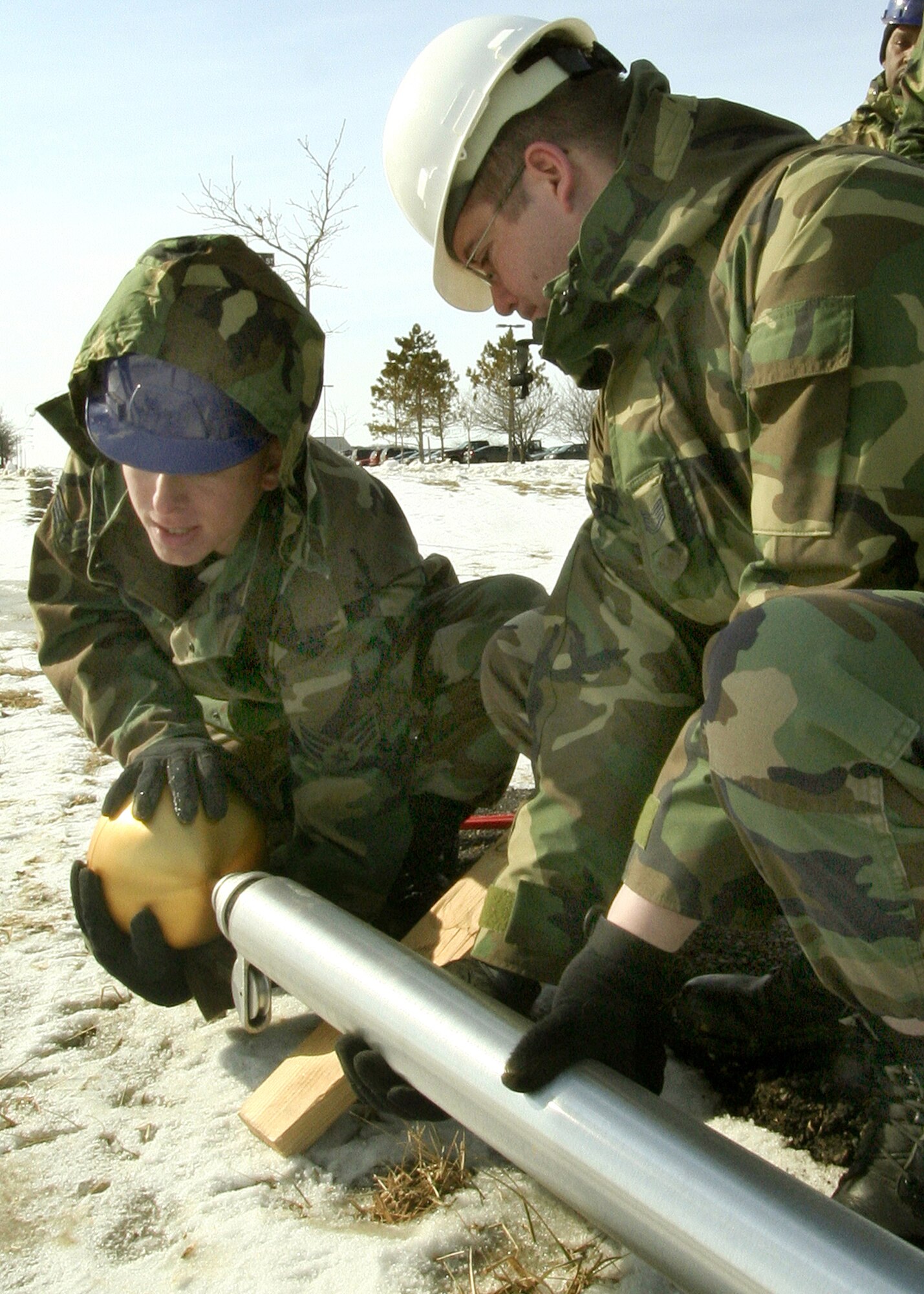 GRISSOM AIR RESERVE BASE, Ind., -- Senior Airman Matthew Crummel, left,  and Tech. Sgt. Daniel Sharp attach a gold ball to the top of the base flag pole. Both are members of the 434th Civil Engineers Squadron. The flag pole is located just north of the intersection of Grissom Avenue and Boxcar Street and dedicated Airmen perform a retreat ceremony every day. (U.S. Air Force Photo/Tech. Sgt. Patrick M. Kuminecz)
