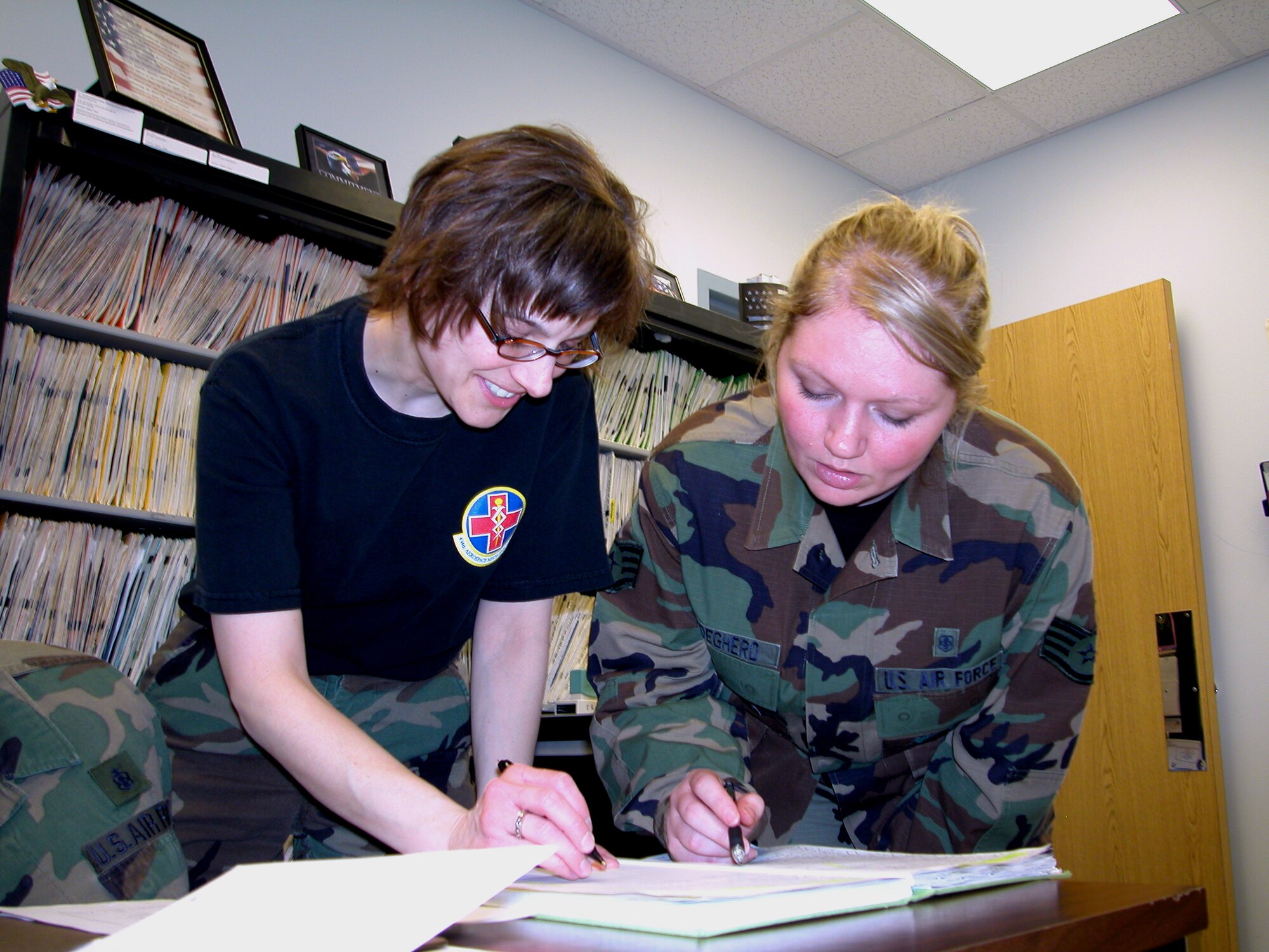 GRISSOM AIR RESERVE BASE, Ind., -- Tech Sgt. Nancy Johnson and Staff Sgt. Rachel Rodeghero, dental technicians with the 434th Aerospace Medicine Squadron dental clinic, review the clinic sign in roster  during a busy unit training assembly. All personnel receiving a "long" physical must be evaluated by a military dentist. (Air Force photo/Senior Airman Chris Bolen)