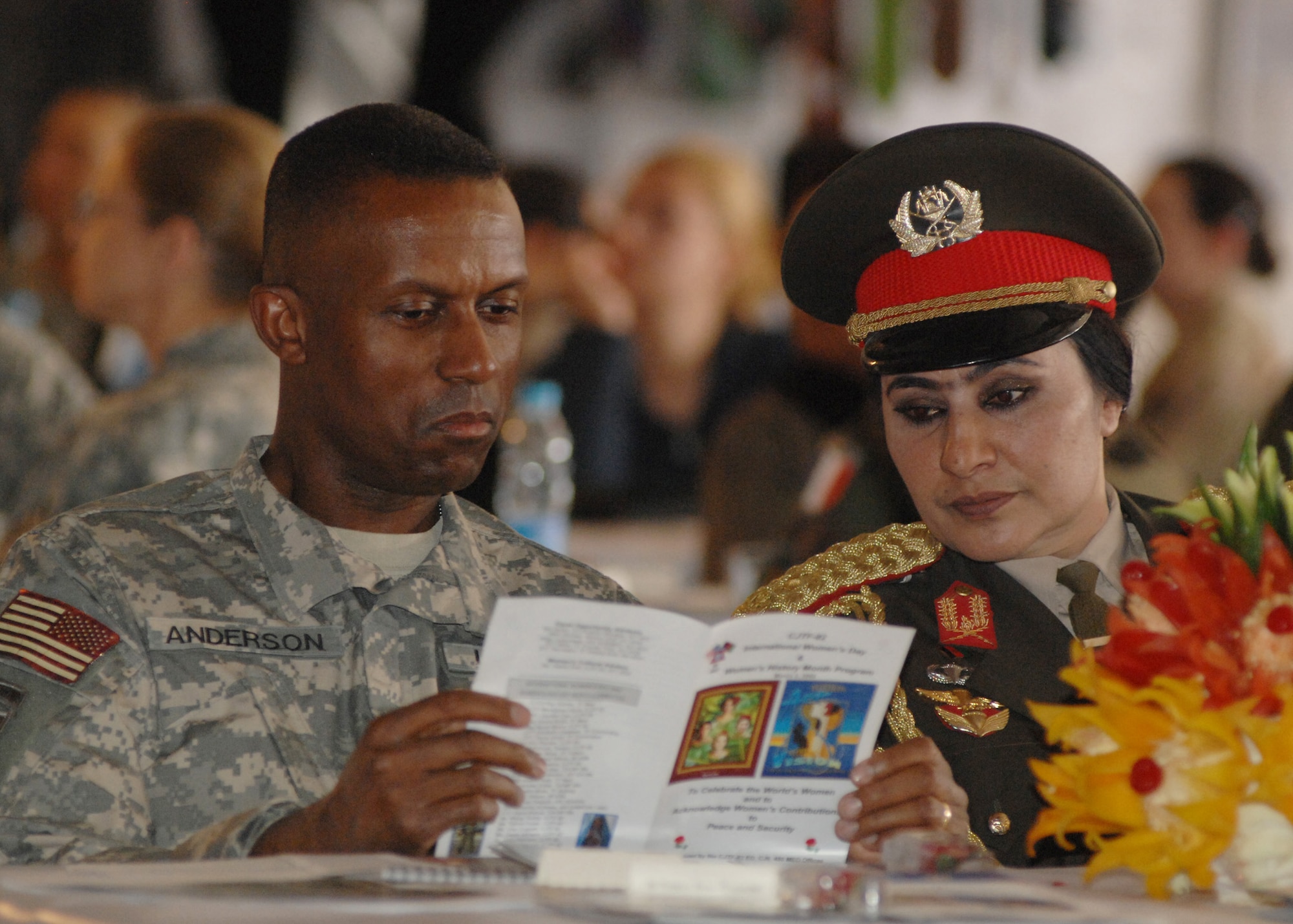 BAGRAM AIR BASE, Afghanistan -  Brig. Gen. Rodney Anderson, Combined Joint Task Force-82 deputy commanding general-support and Brig. Gen. Khatool Mohammadzai, Afghan National Army, look through a program during the International Women's Day held here March 3. Hundreds turned out to the festivities and celebrated the world's women and acknowledged women's contributions to peace and security. (U.S. Air Force photo by Master Sgt. Demetrius Lester) 