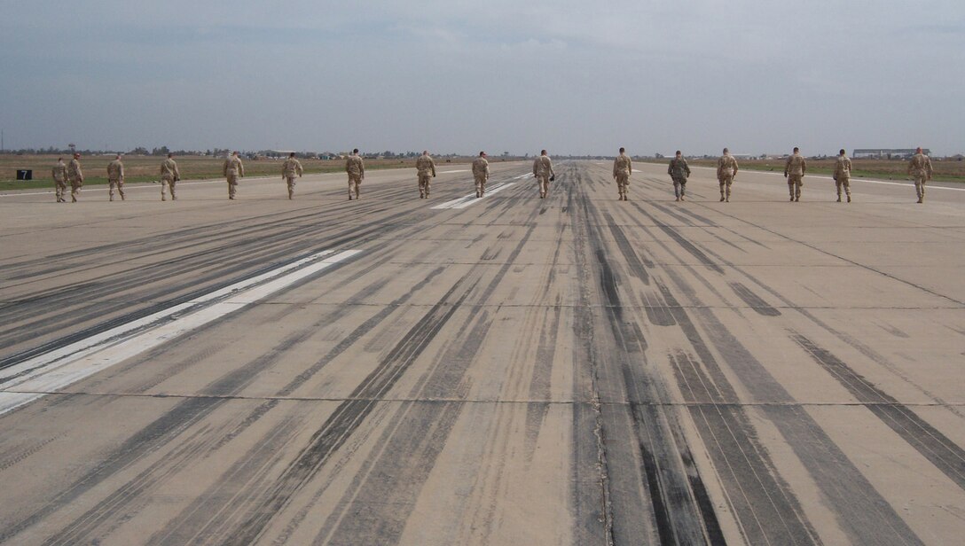 KIRKUK REGIONAL AIR BASE, Iraq -- Airmen from the 506th Air Expeditionary Group conduct a foreign object damage (FOD) walk prior to a barrier engagement test Feb. 29 here. These walks help prevent stray objects from entering the engine of an F-16 and are crucial to the success of the barrier engagement. 

The barrier engagement tests the Mobile Aircraft Arresting System, which is designed to reduce the forward energy of a fighter aircraft during an emergency landing. The MAAS consists of twin platforms connecting a cable that runs across the runway. During an emergency landing, a fighter pilot can drop a hook that latches onto the MAAS cable. The connection reduces the forward energy of the fighter aircraft which cushions impact. Though no fighters are assigned to Kirkuk, these aircraft could be diverted here for reasons ranging from bad weather to mechanical problems. The barrier engagement involved efforts from the 506th Expeditionary Operations Support Squadron, Civil Engineer Squadron, Logistics Readiness Squadron, Security Forces Squadron and Communication Squadron. The two F-16s that participated in the engagement were from the 421st Expeditionary Fighter Squadron. (U.S. Air Force photo by Maj. Stephen Miceli) 